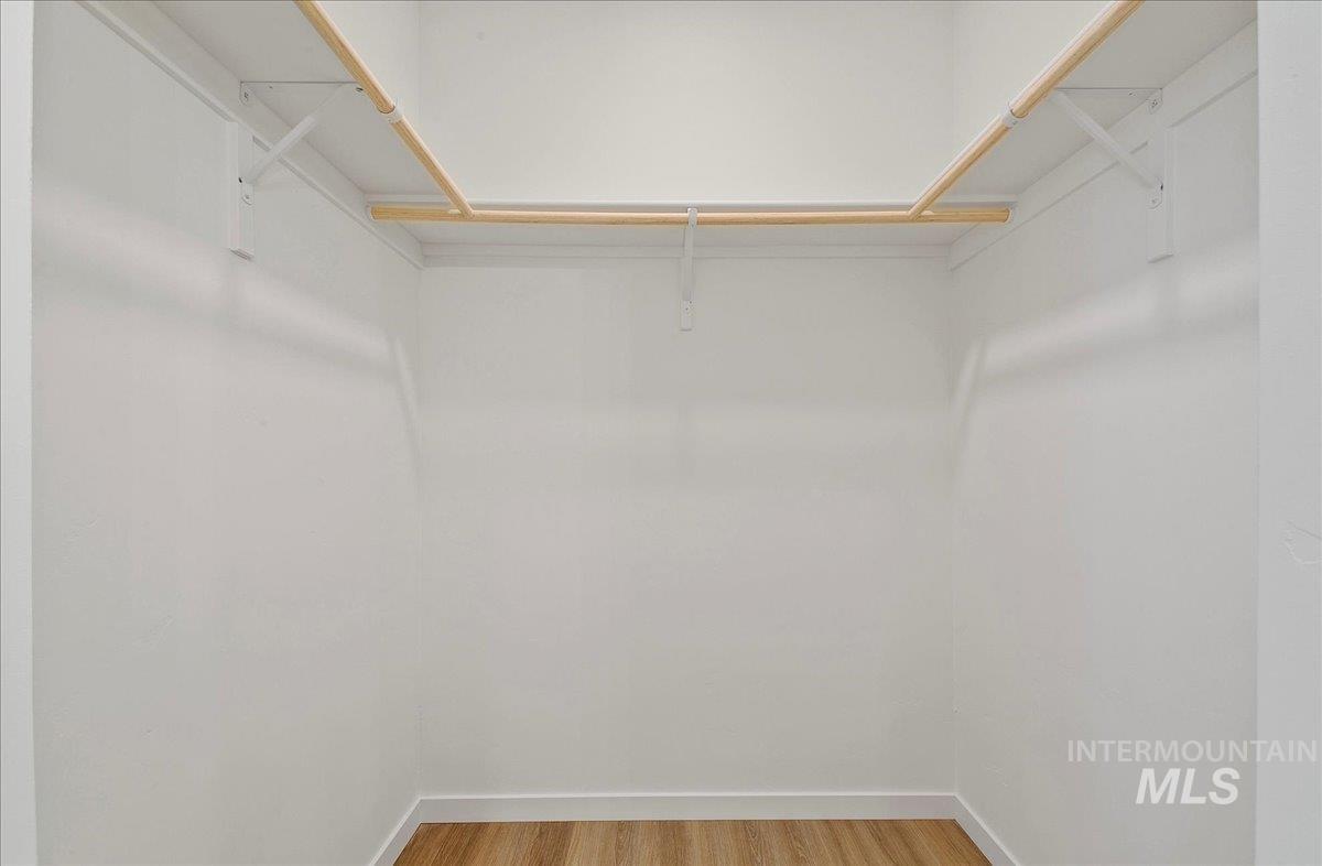 Spacious closet featuring light wood-style flooring