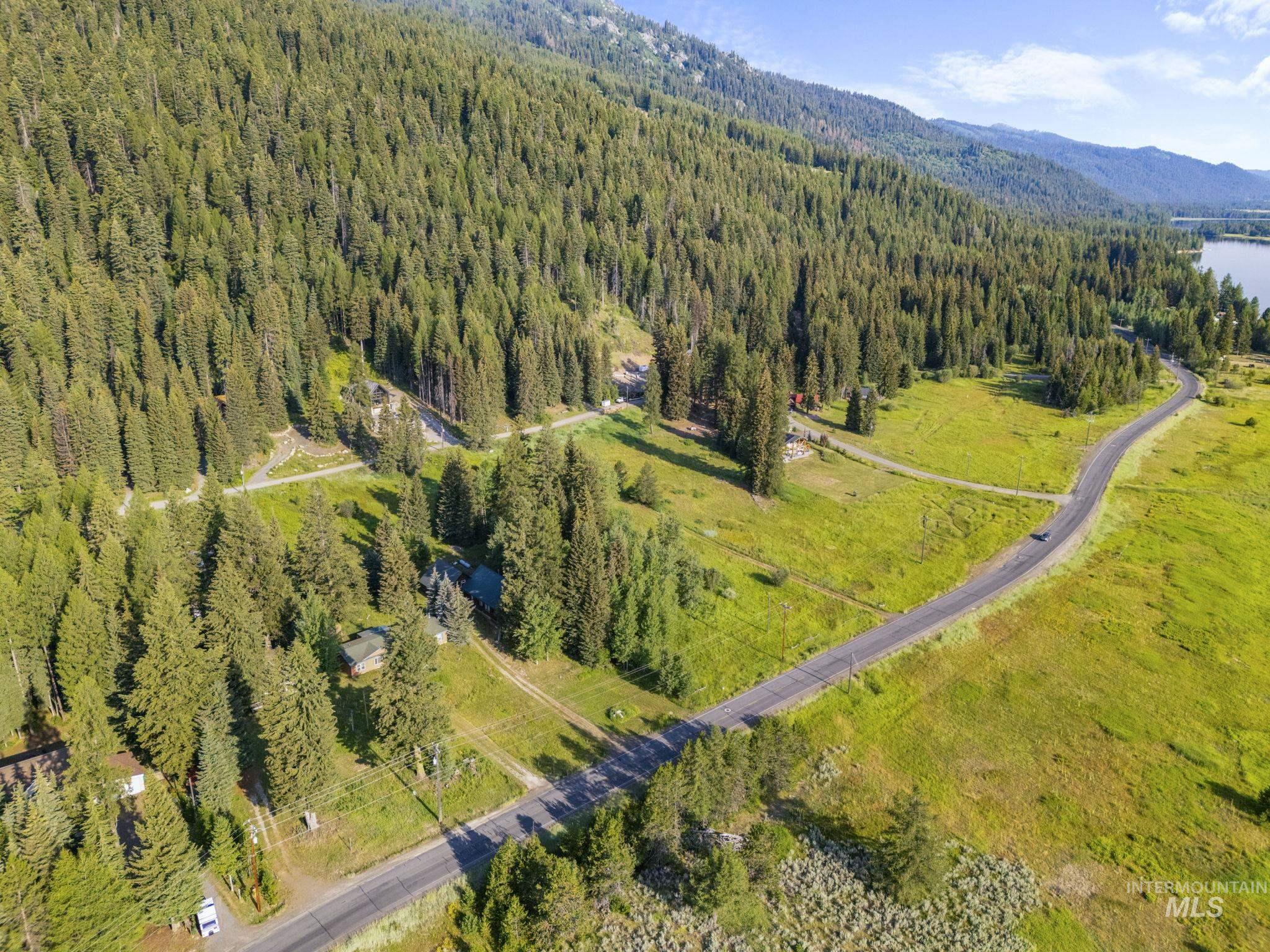 Aerial view of property's location featuring mountains and a heavily wooded area