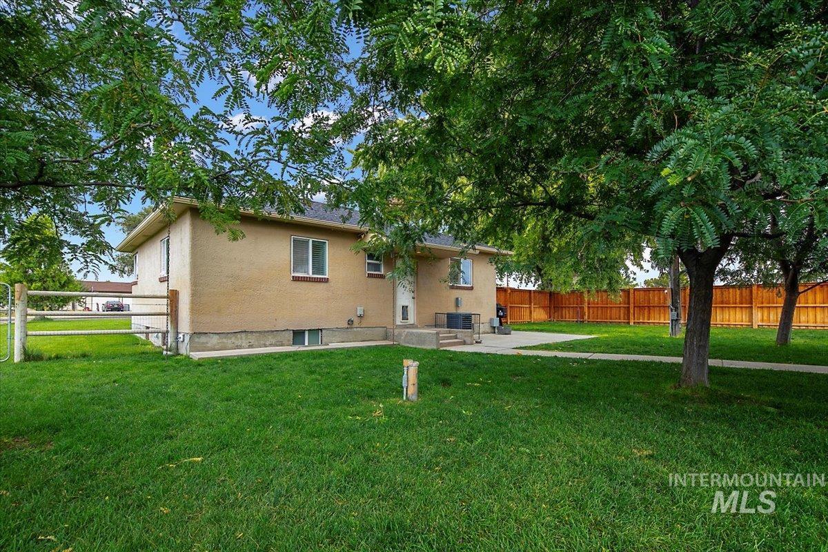 Back of property featuring a fenced backyard, stucco siding, and a patio area