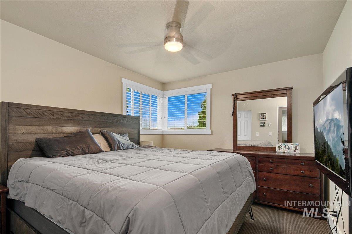Carpeted bedroom with a ceiling fan