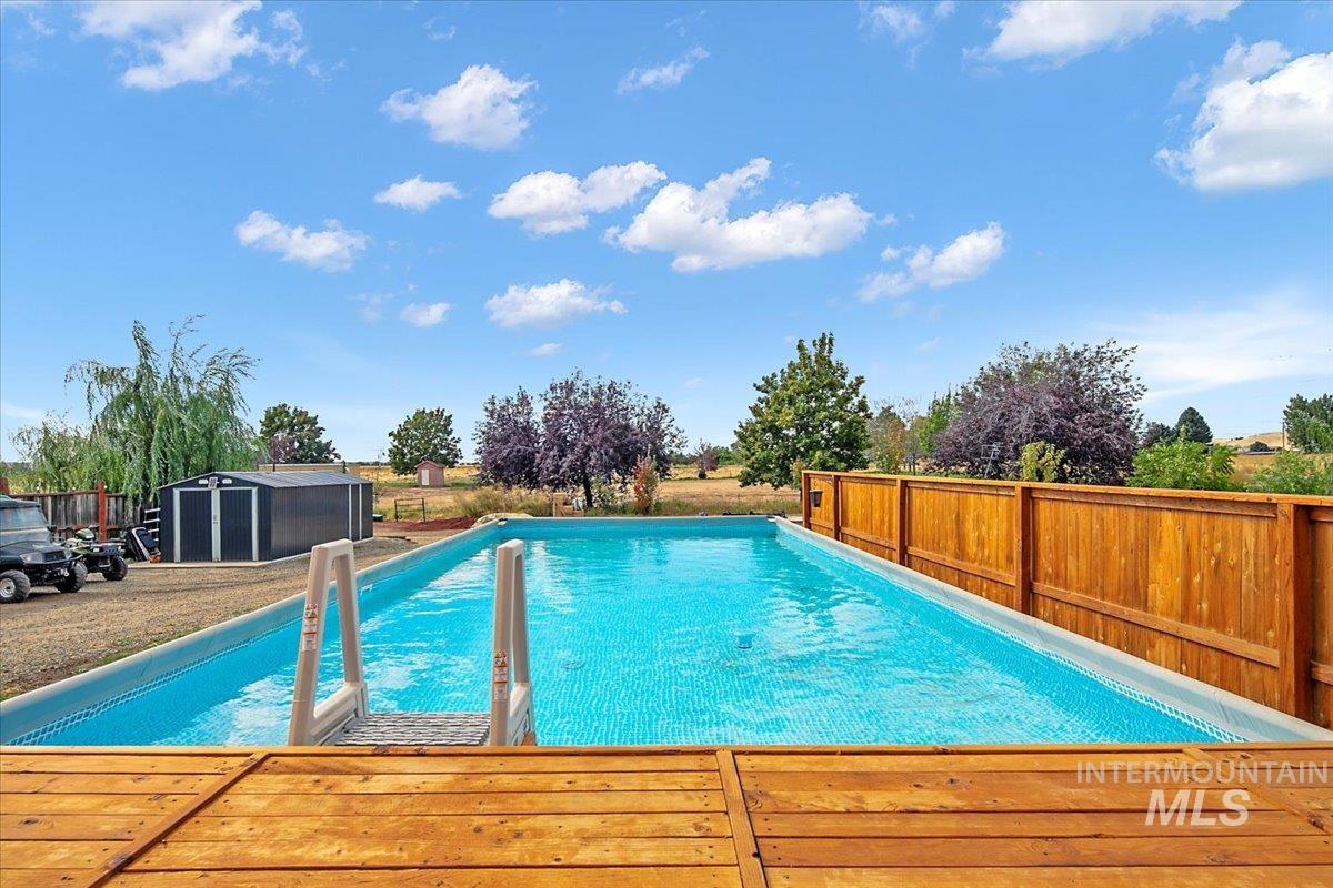 Swimming pool featuring a shed and a wooden deck
