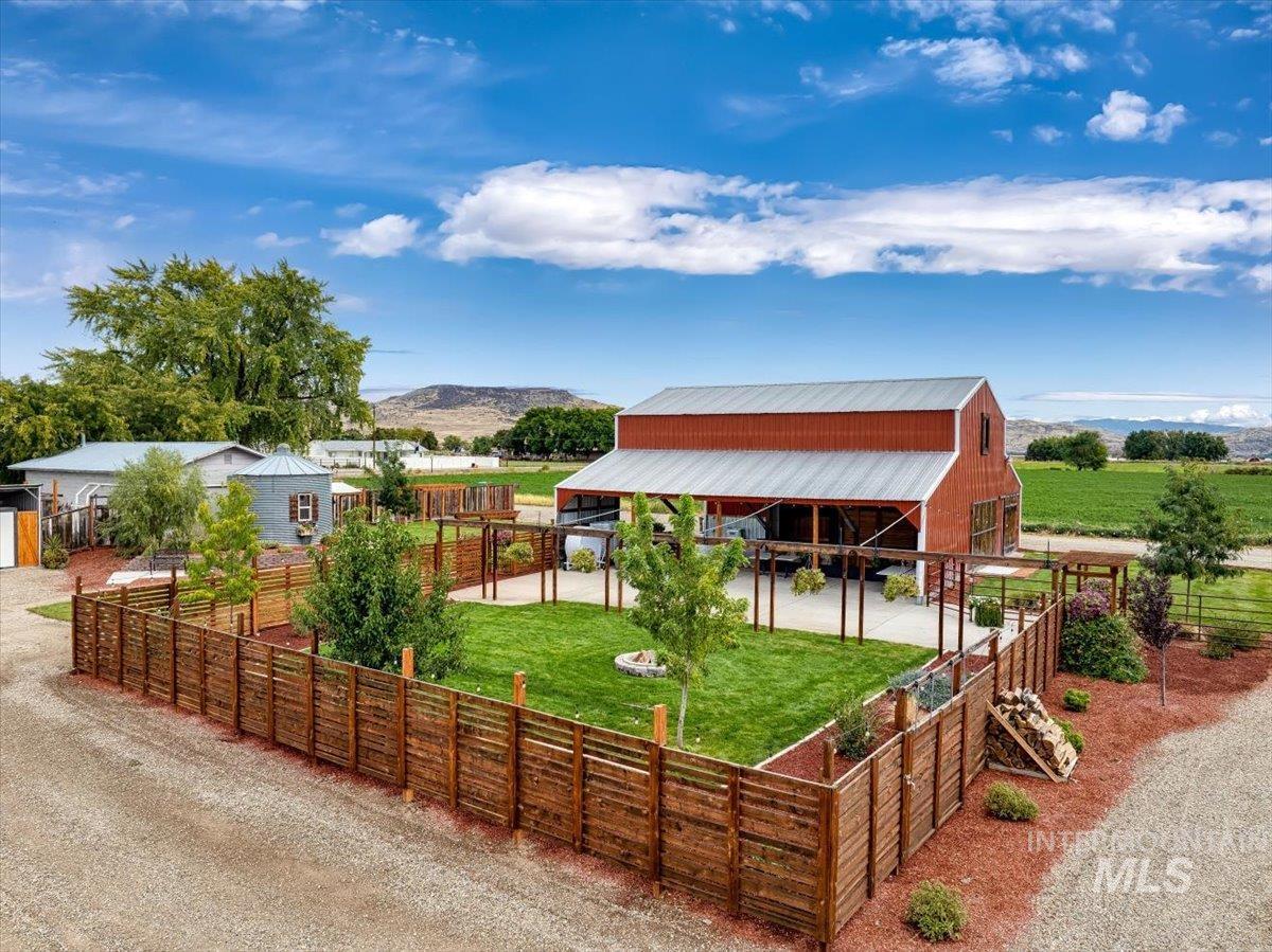 View of front of home featuring an outbuilding, a patio, a mountain view, and a rural view