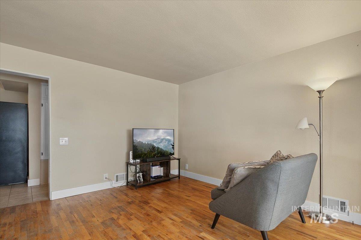 Living area featuring light wood-style floors and a textured ceiling