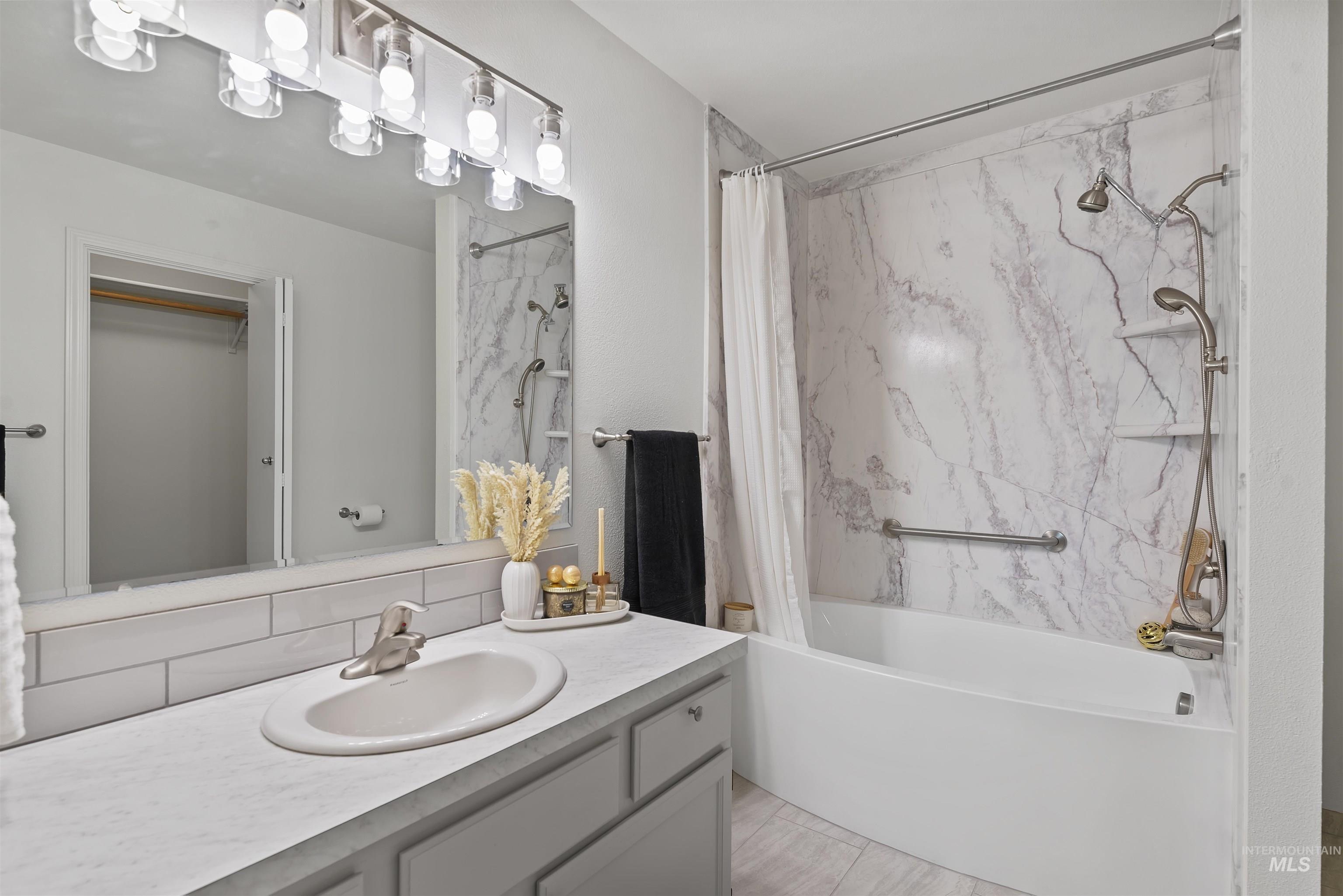 Full bathroom featuring shower / tub combo with curtain, vanity, and a spacious closet
