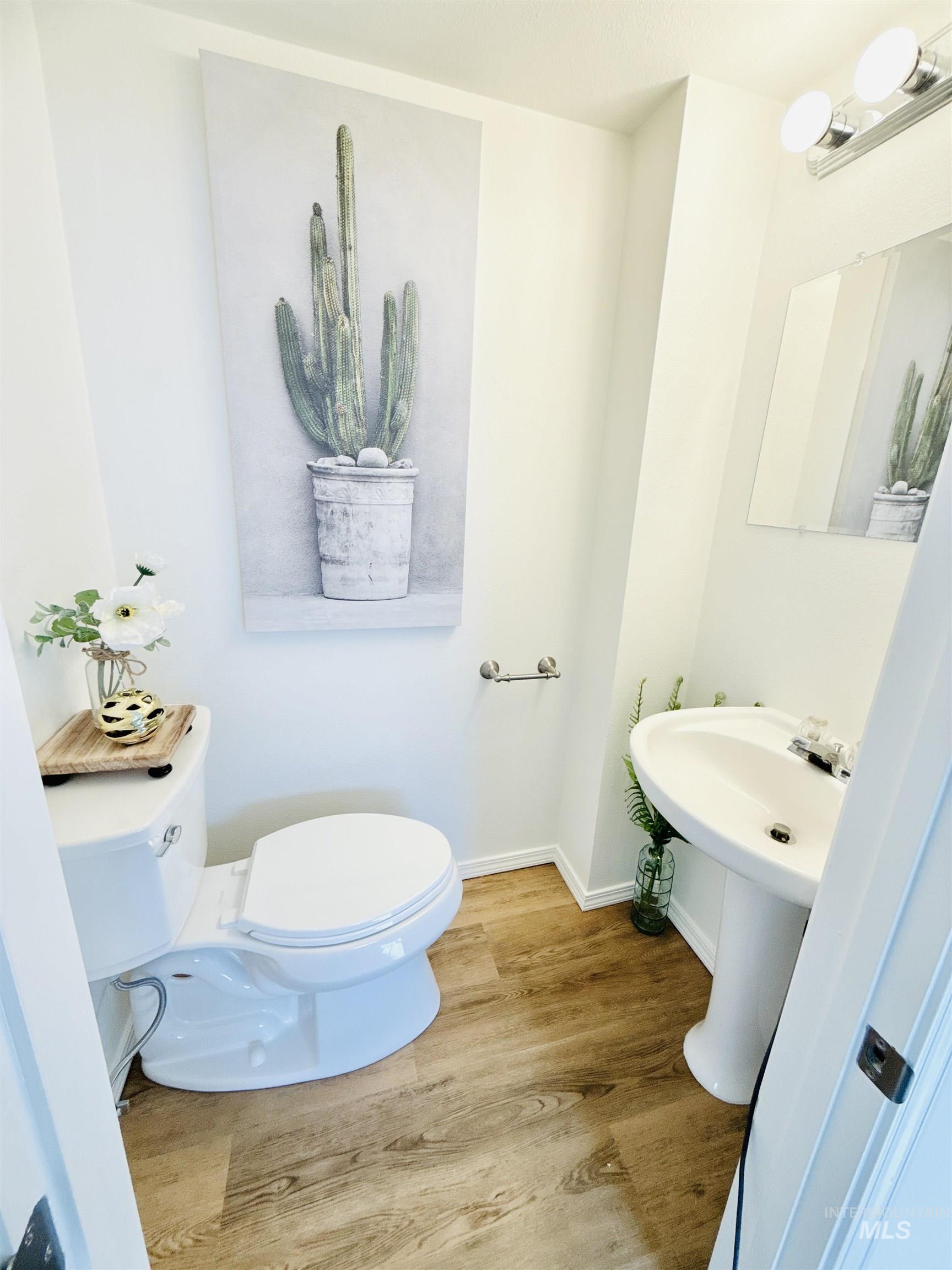 Half bath featuring wood finished floors and toilet