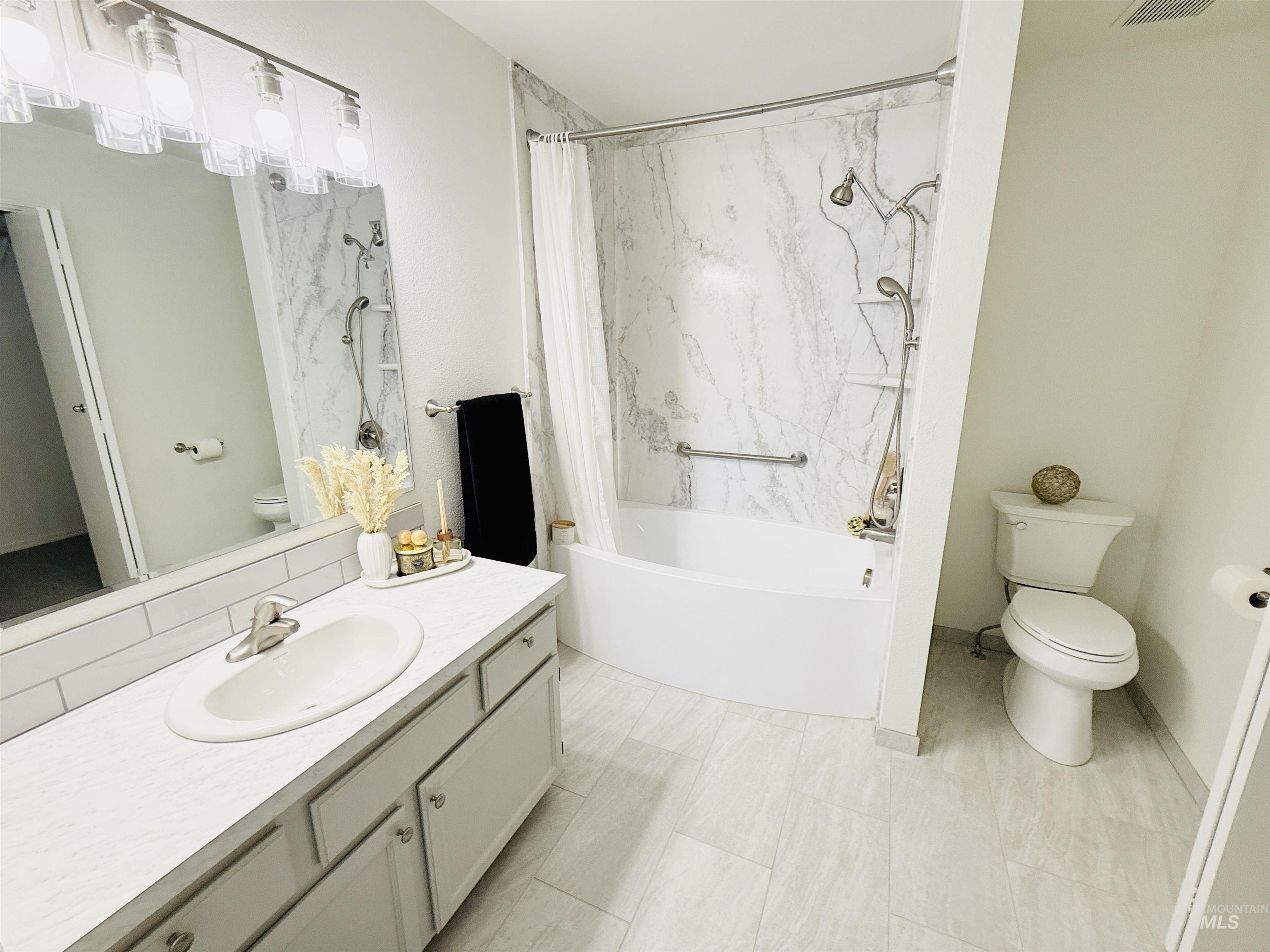 Bathroom with vanity and a combined bath / shower with marble appearance