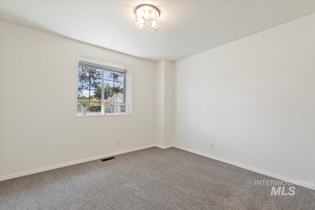 Carpeted spare room with baseboards