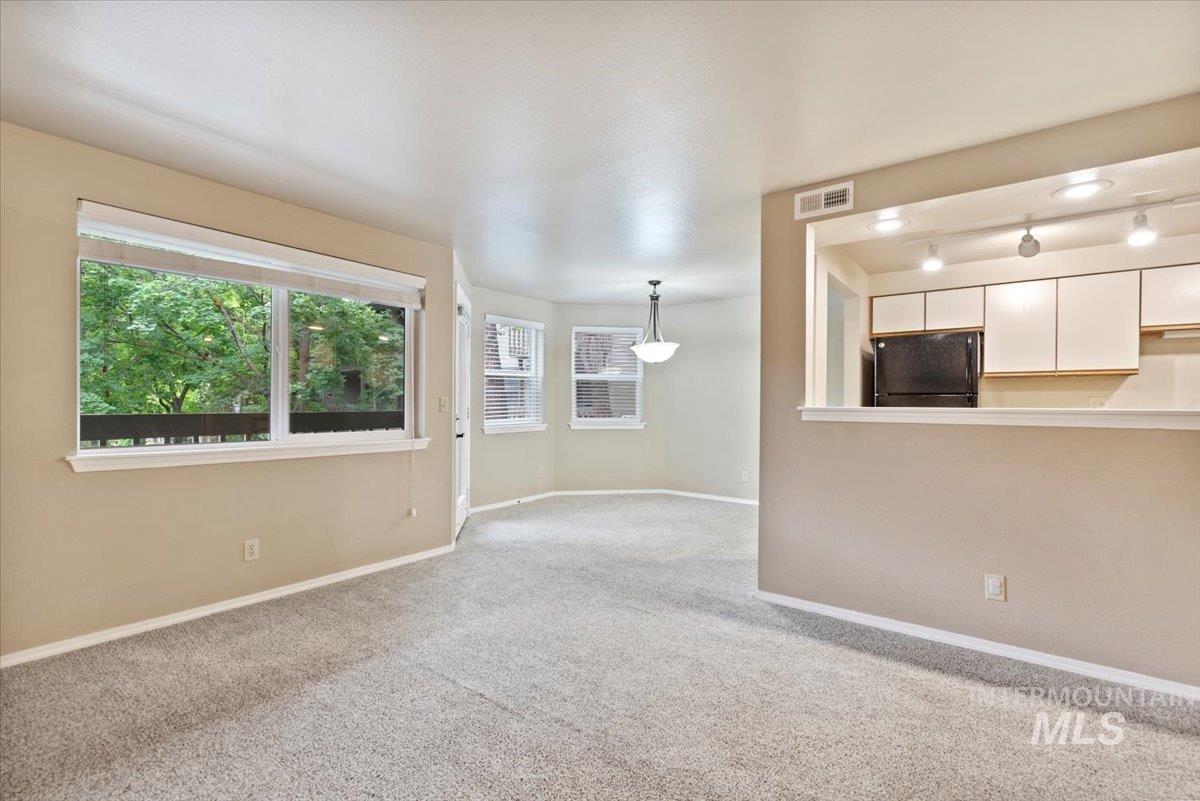 Unfurnished living room with carpet and rail lighting