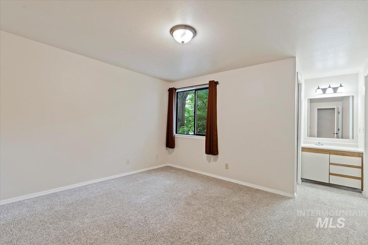 Unfurnished bedroom featuring light colored carpet and baseboards