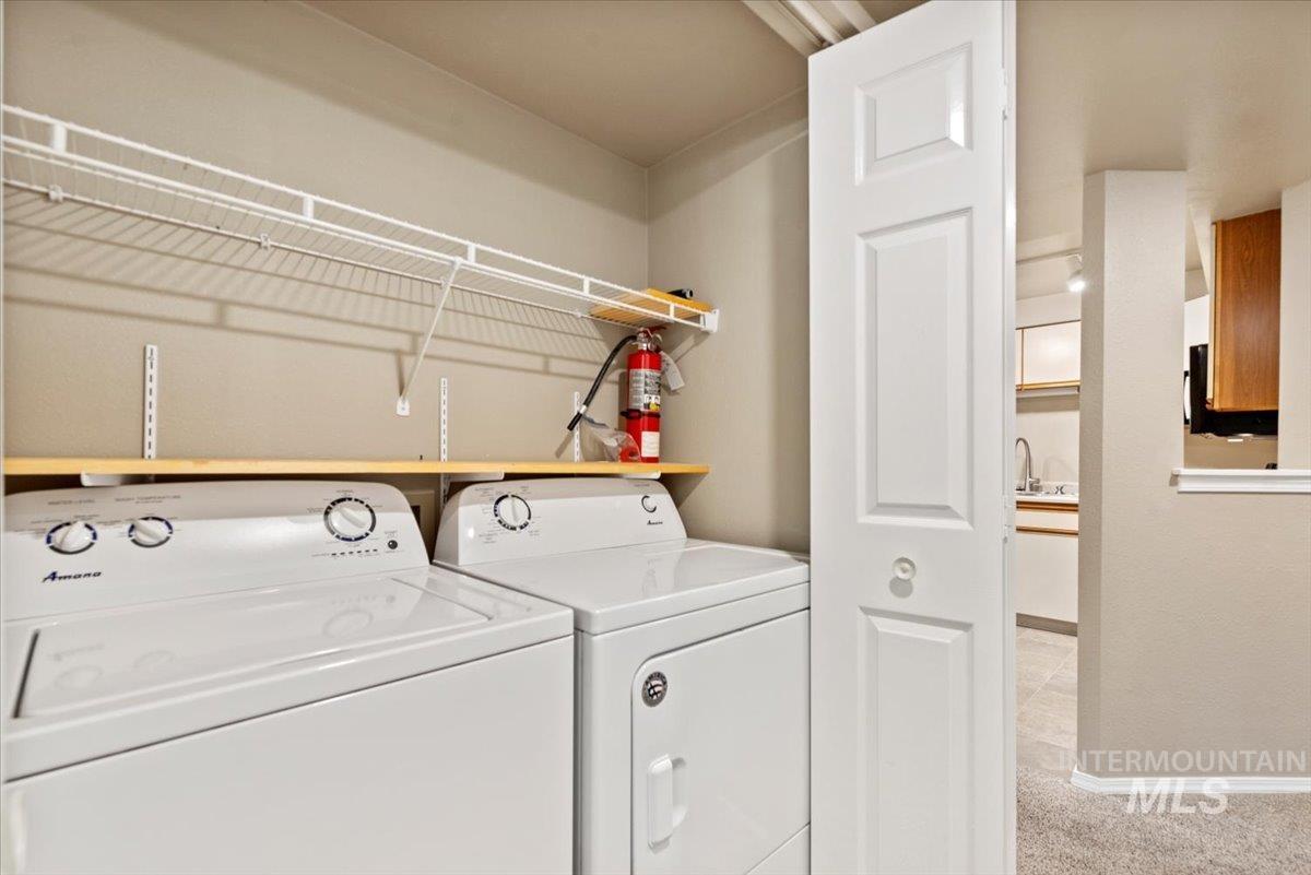 Washroom featuring washer and clothes dryer and light carpet