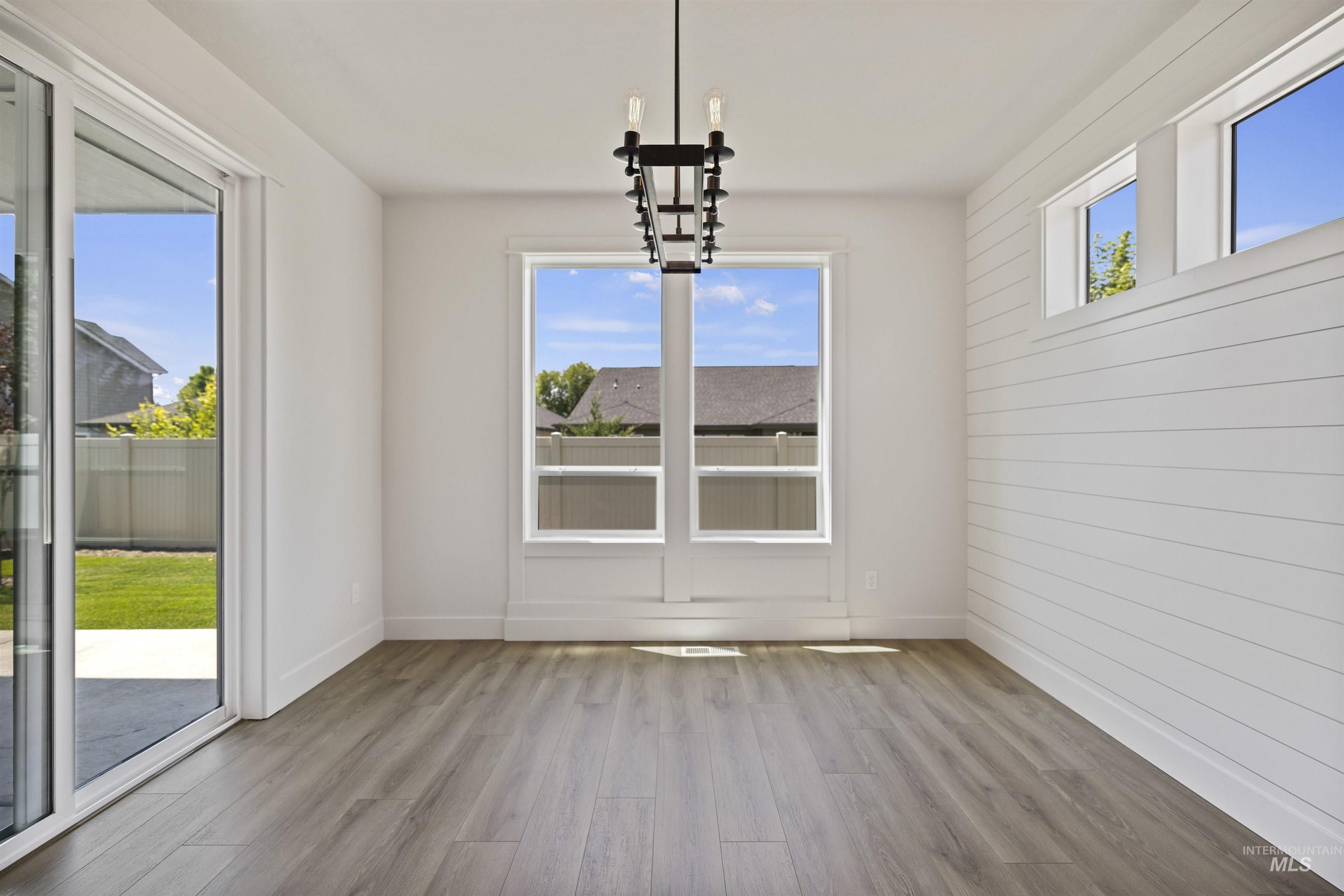 Unfurnished dining area with a chandelier and wood finished floors
