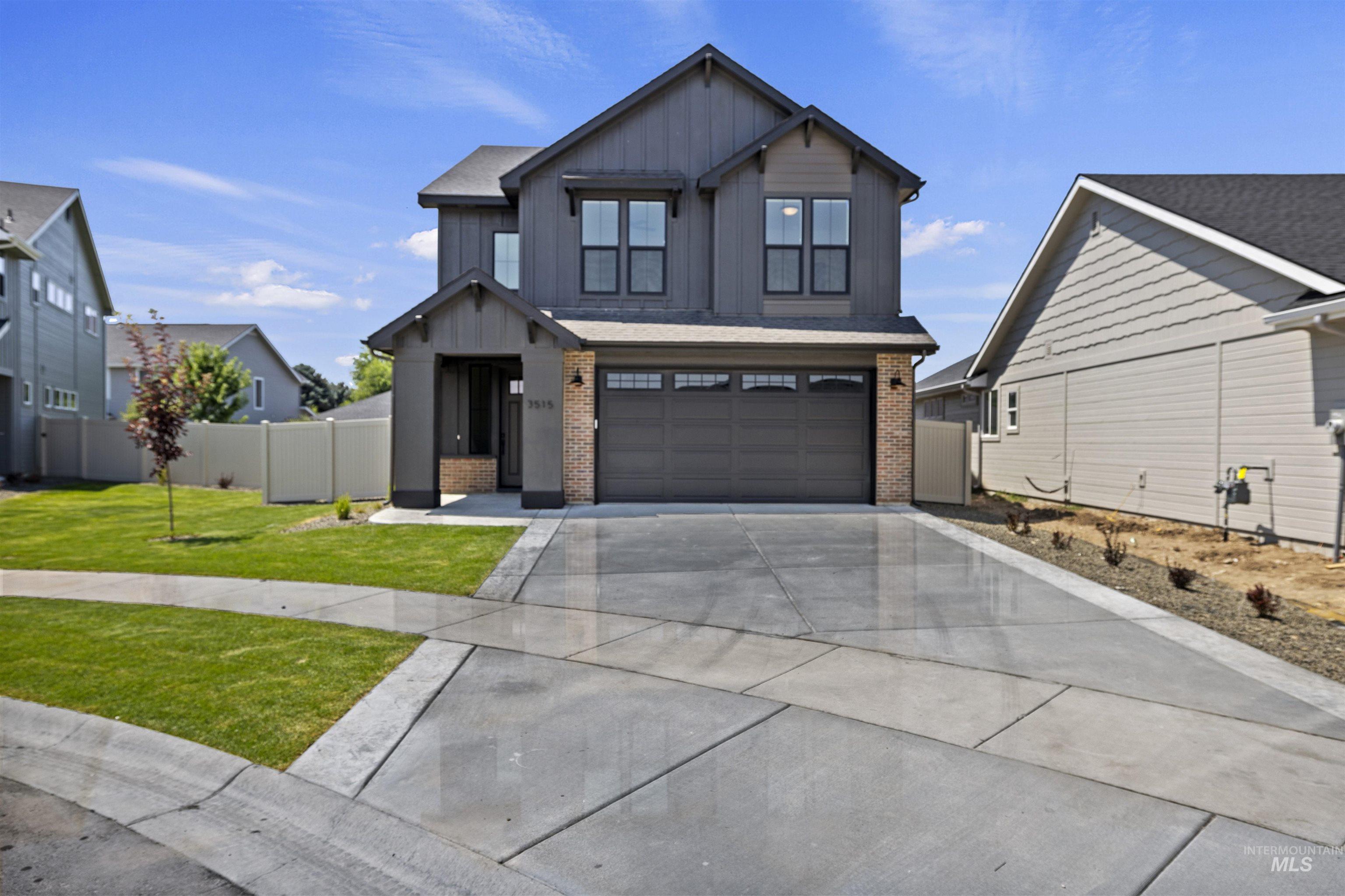 View of front of home featuring brick siding, concrete driveway, board and batten siding, and a garage