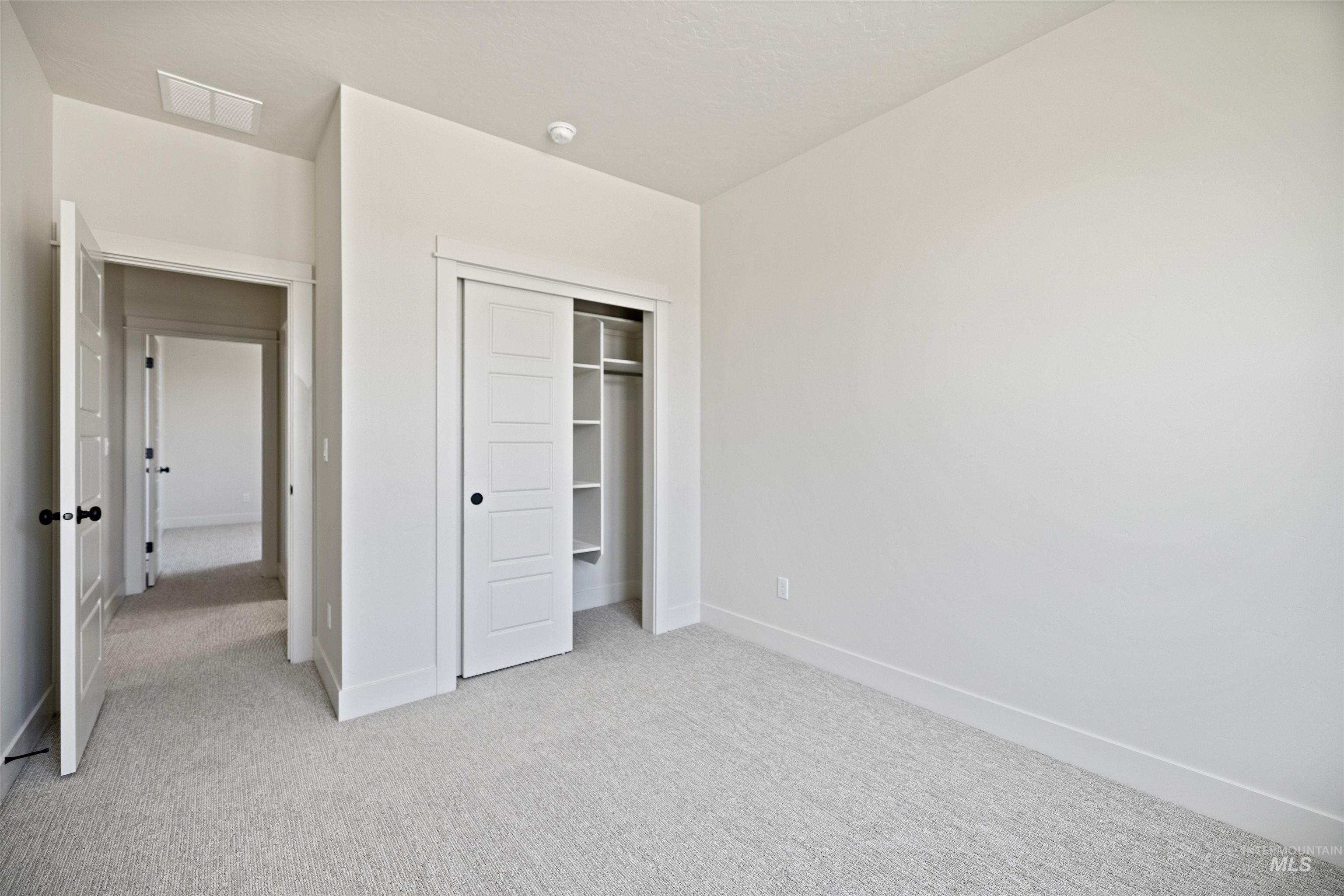 Unfurnished bedroom featuring carpet and a closet