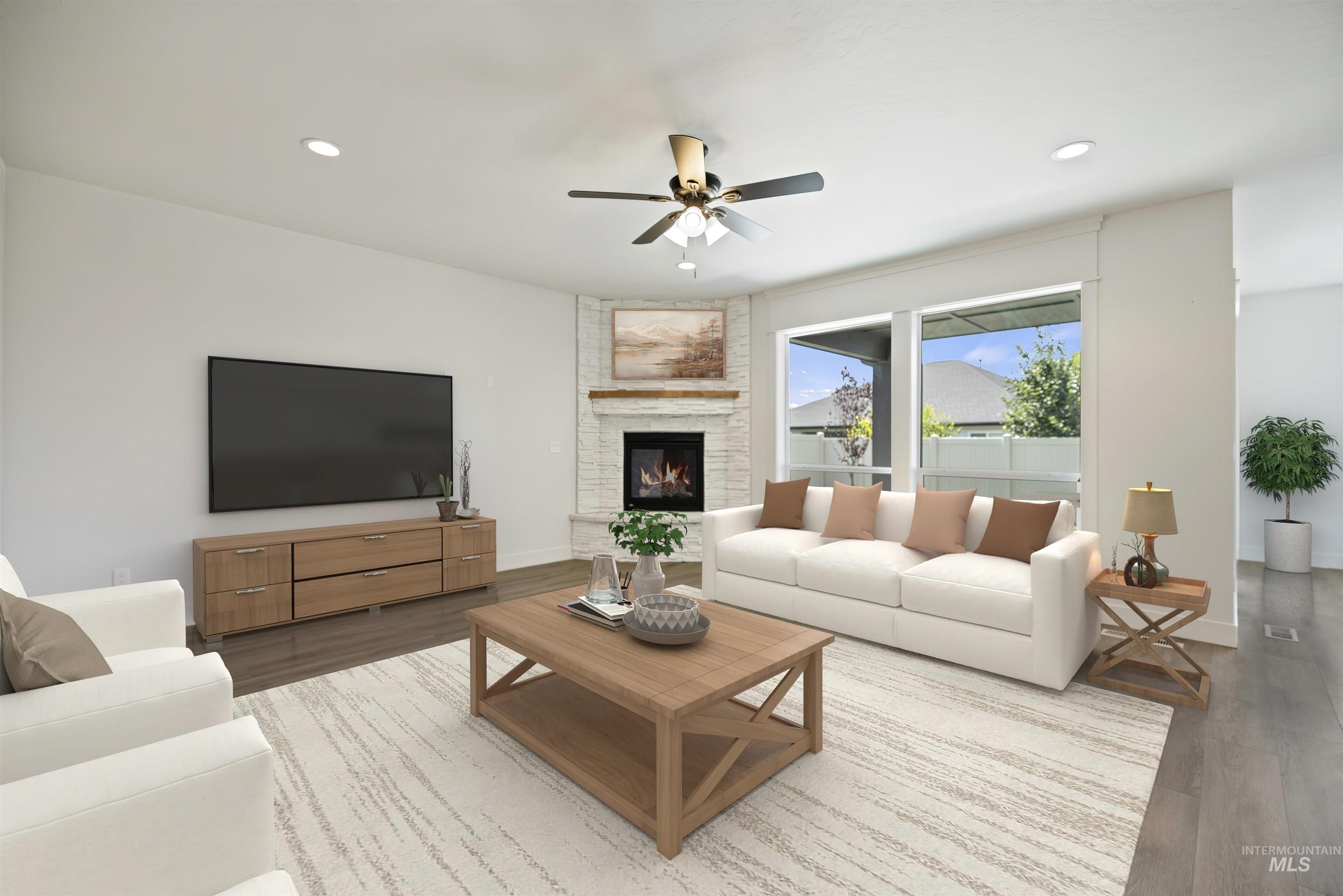 Living area featuring a ceiling fan, wood finished floors, recessed lighting, and a large fireplace