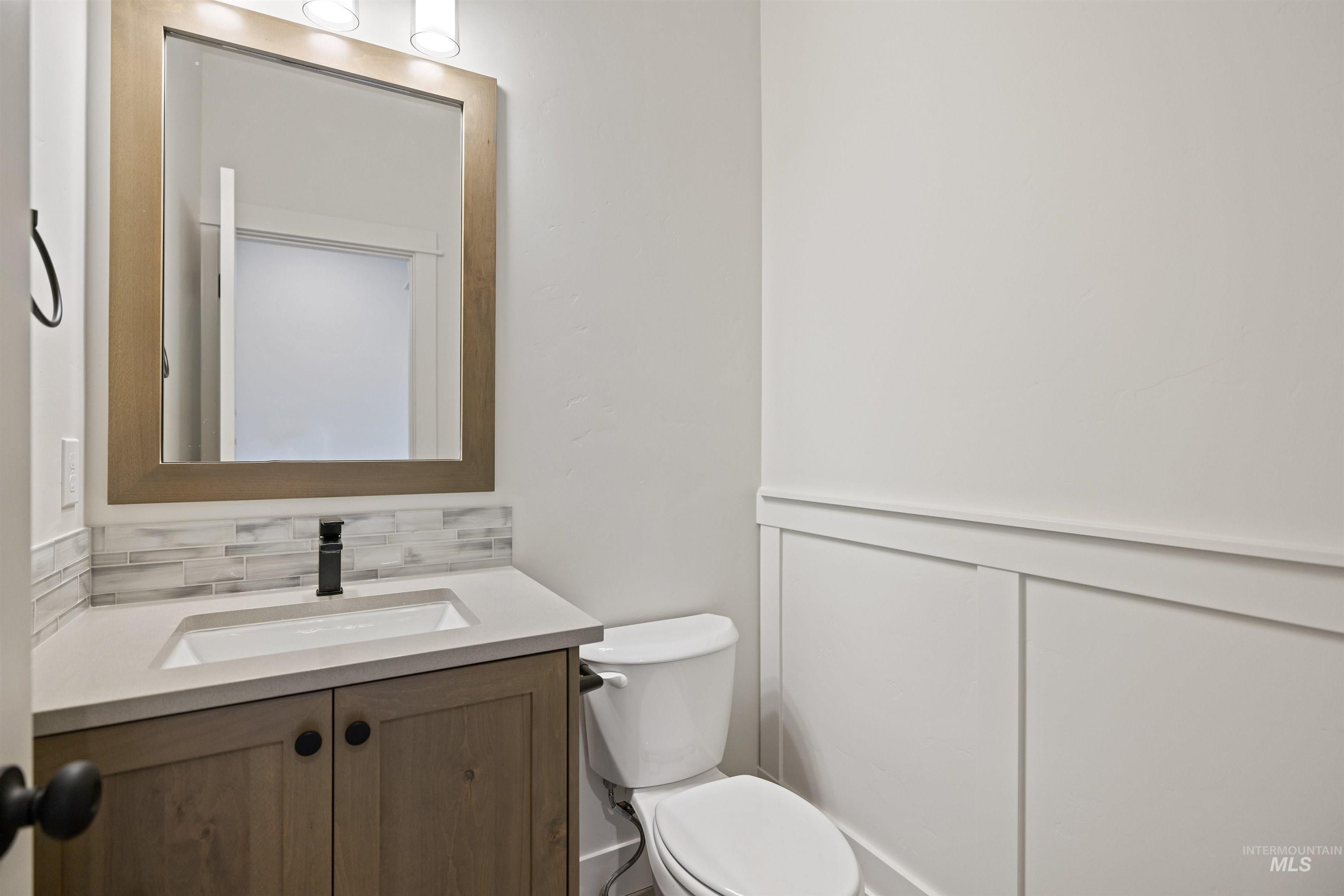 Bathroom featuring vanity and decorative backsplash