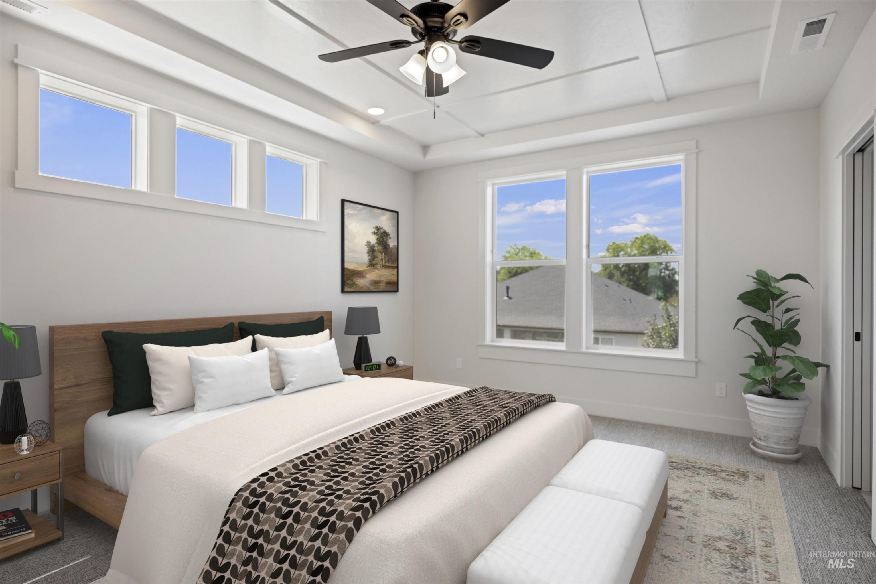 Carpeted bedroom with a tray ceiling and a ceiling fan