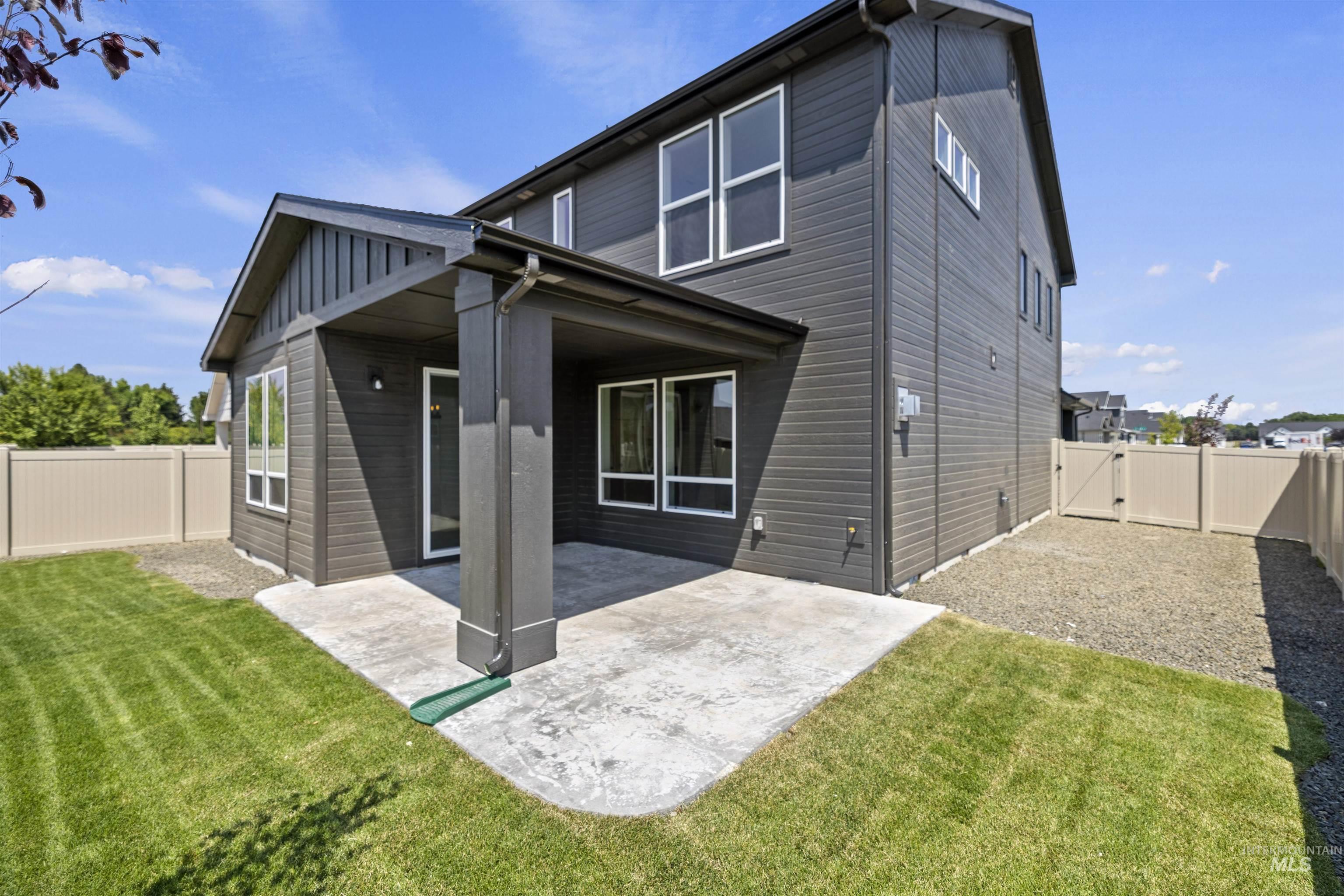 Rear view of house with a patio, a fenced backyard, and a gate