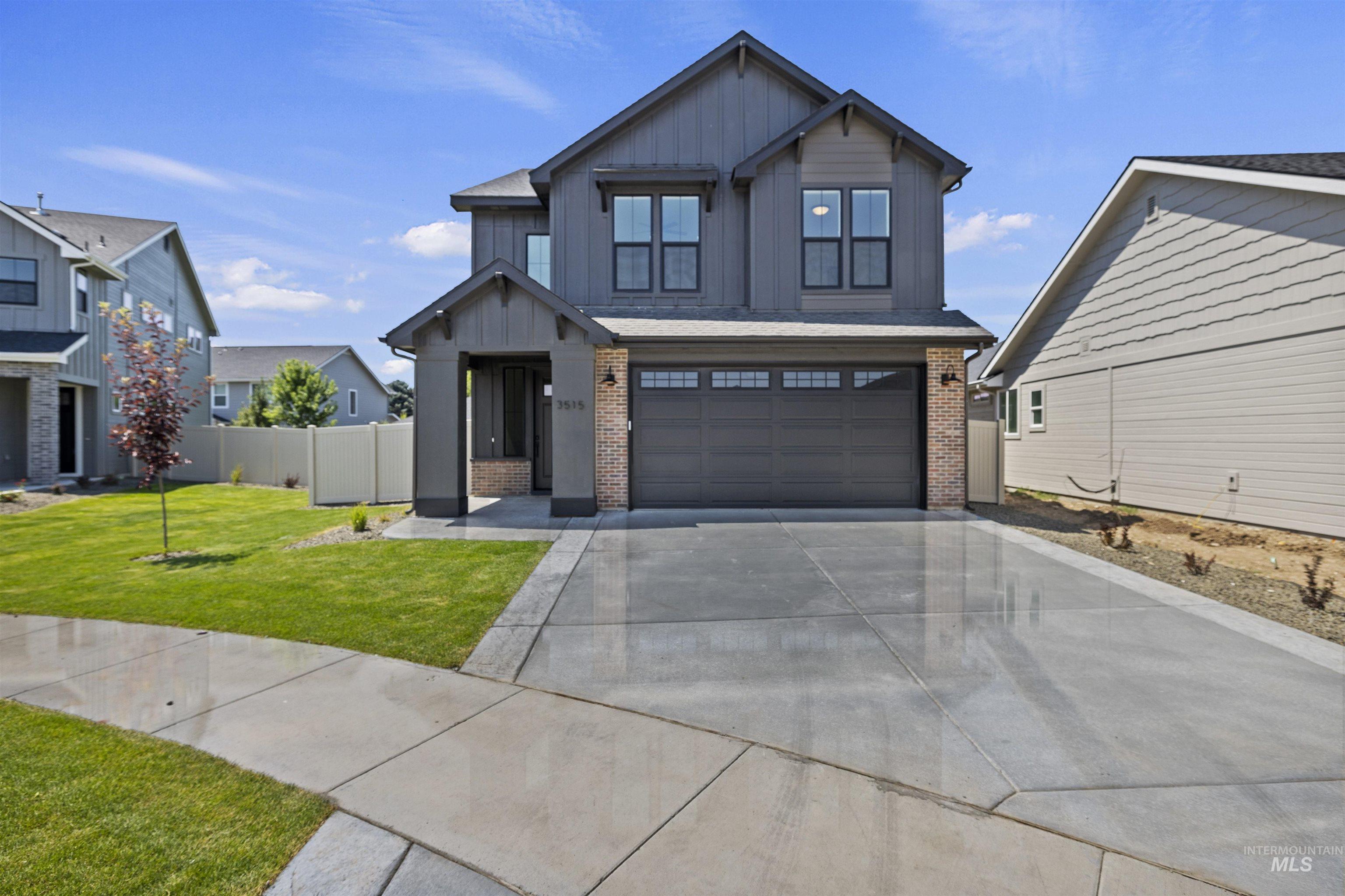 View of front of house with brick siding, board and batten siding, concrete driveway, and an attached garage