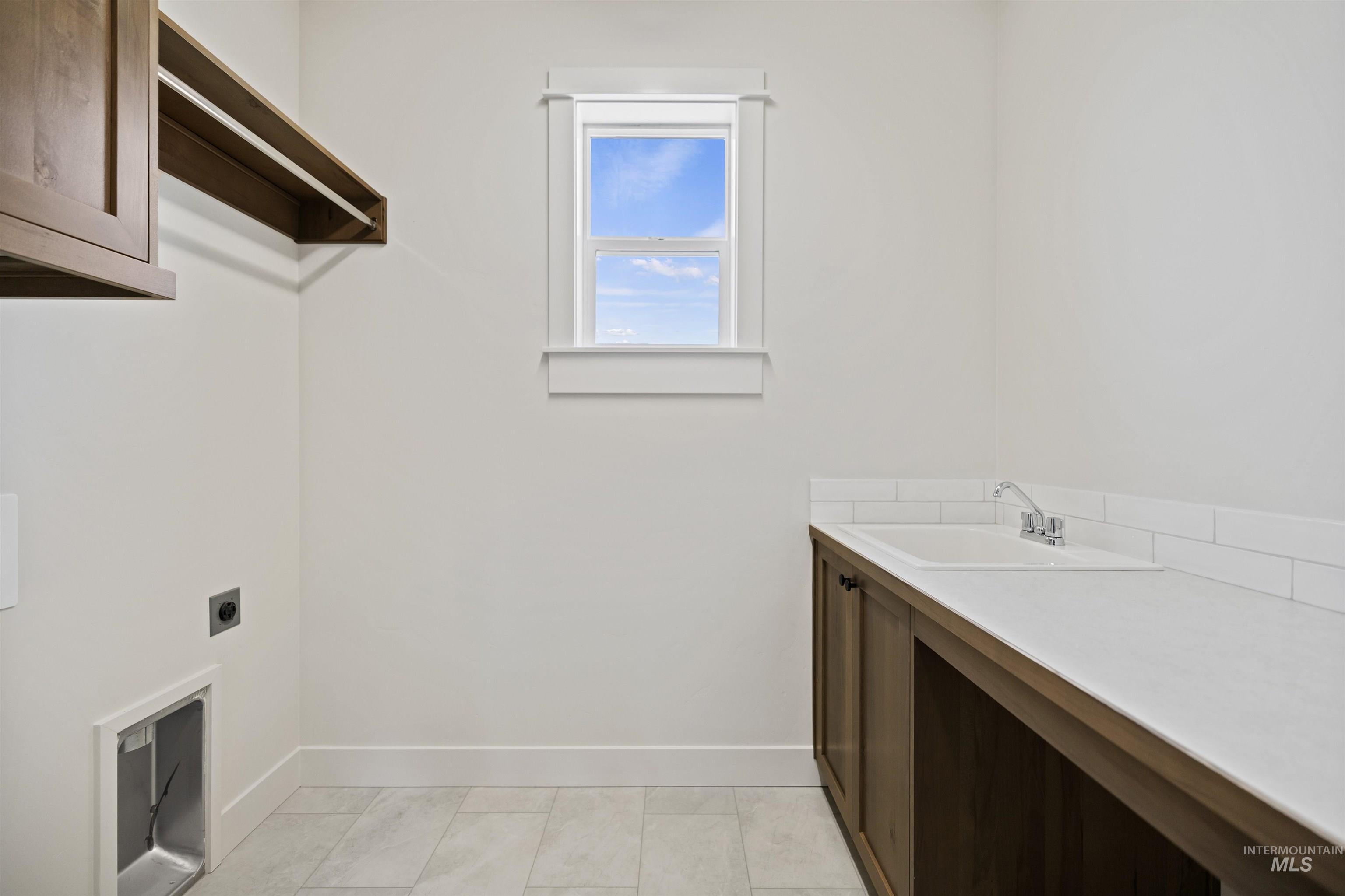 Laundry area featuring hookup for an electric dryer and cabinet space