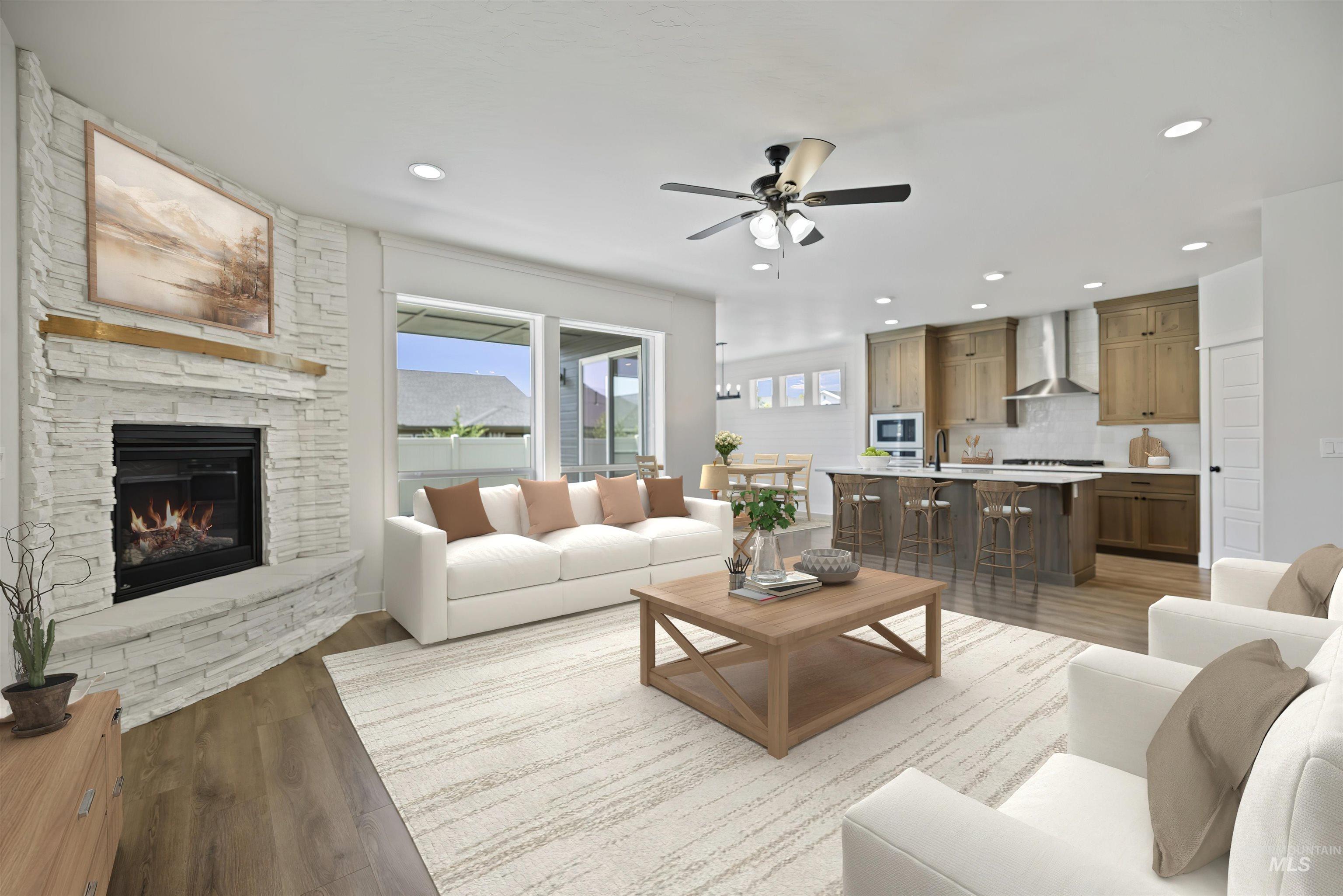 Living area featuring ceiling fan, light wood-type flooring, a fireplace, and recessed lighting