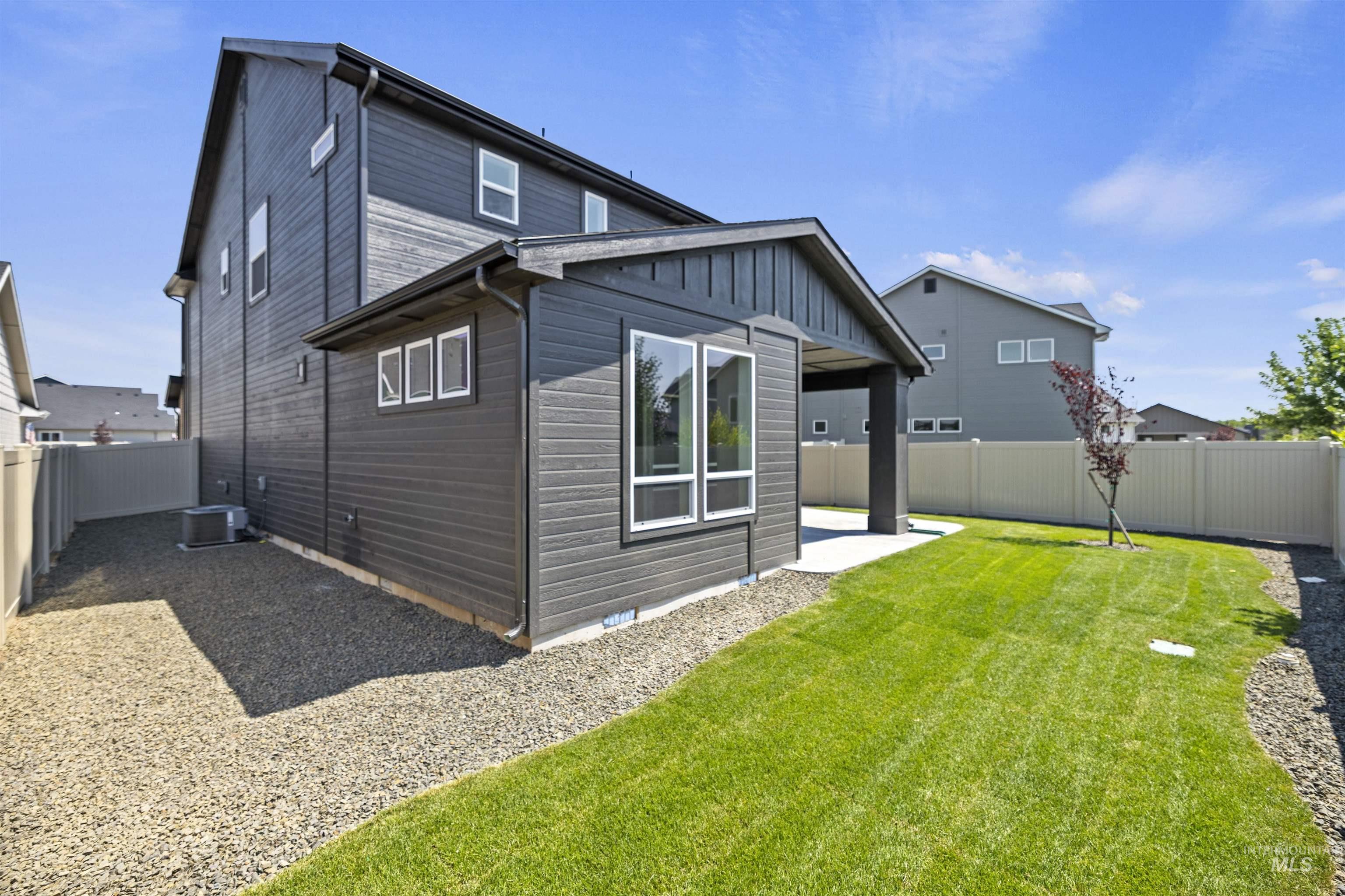 Rear view of house featuring a fenced backyard, a patio area, and board and batten siding