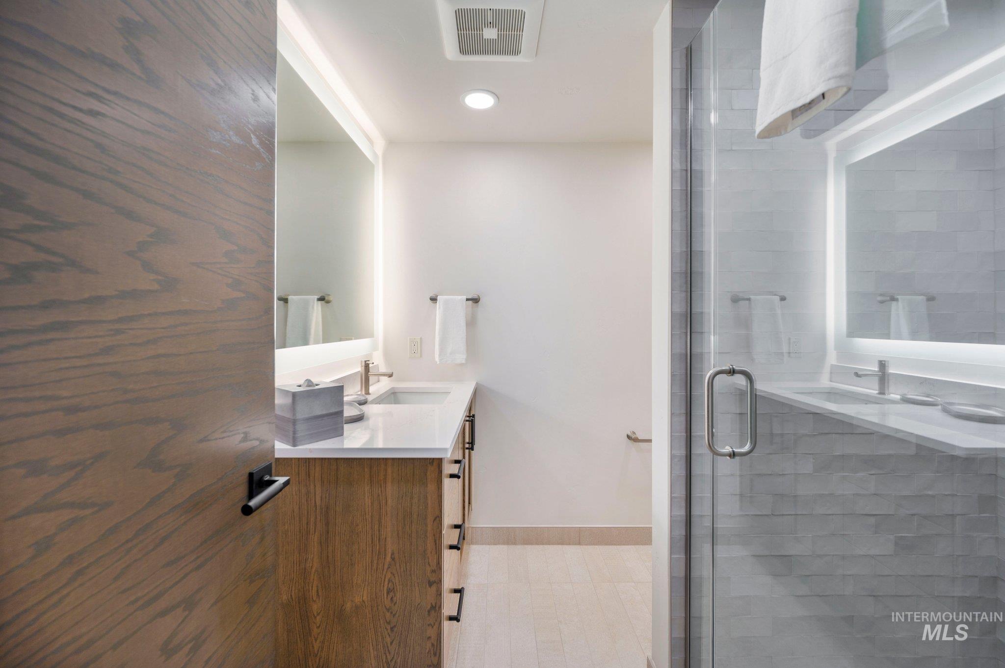 Full bath with vanity, a shower stall, and recessed lighting