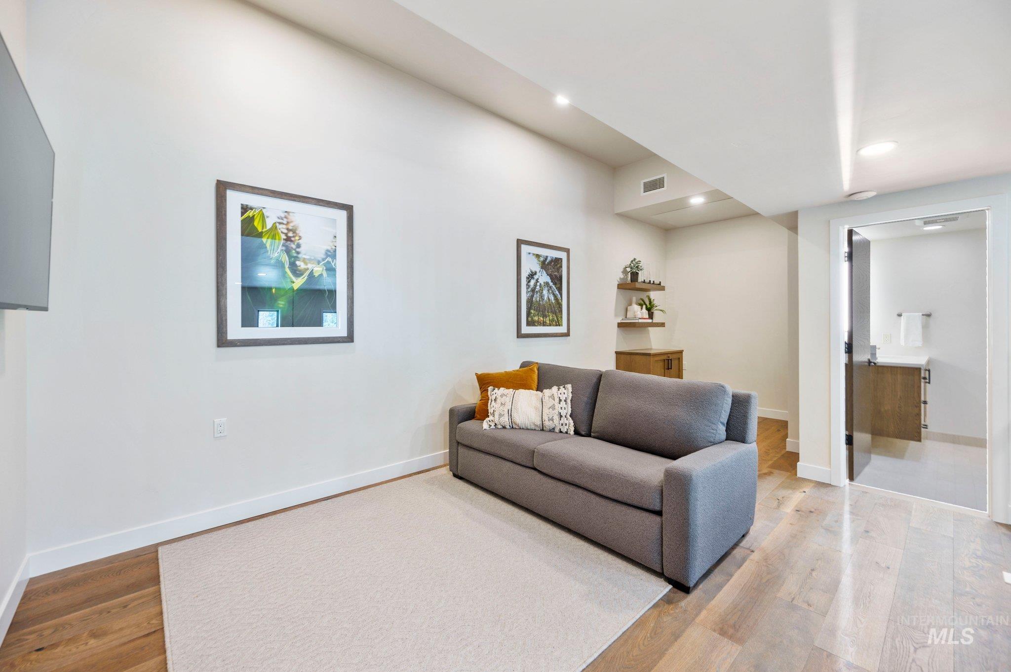 Living area featuring light wood-style floors and recessed lighting
