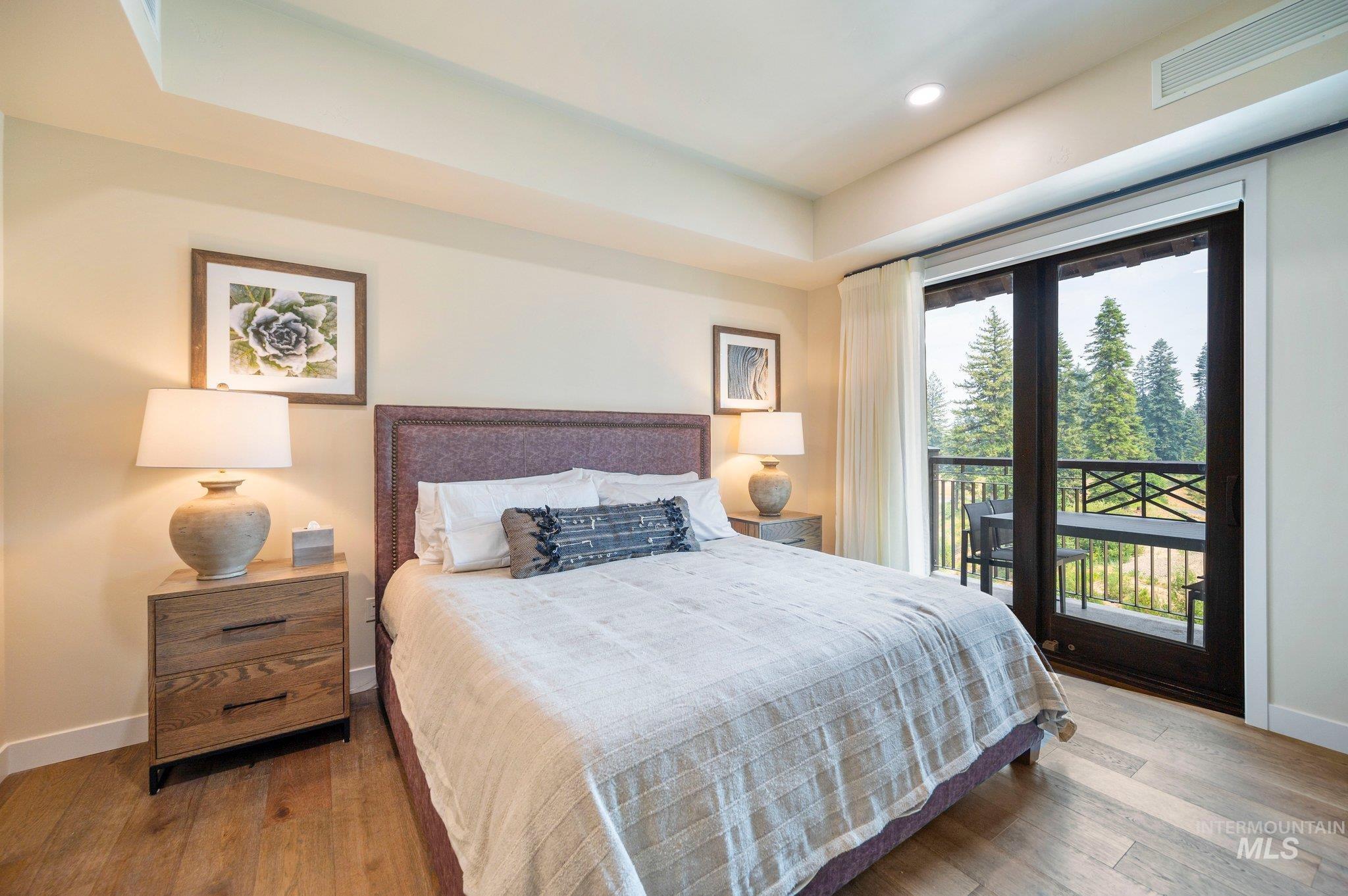 Bedroom with access to exterior, hardwood / wood-style flooring, and recessed lighting