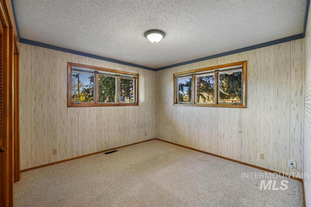 Unfurnished room with carpet flooring, a textured ceiling, and ornamental molding