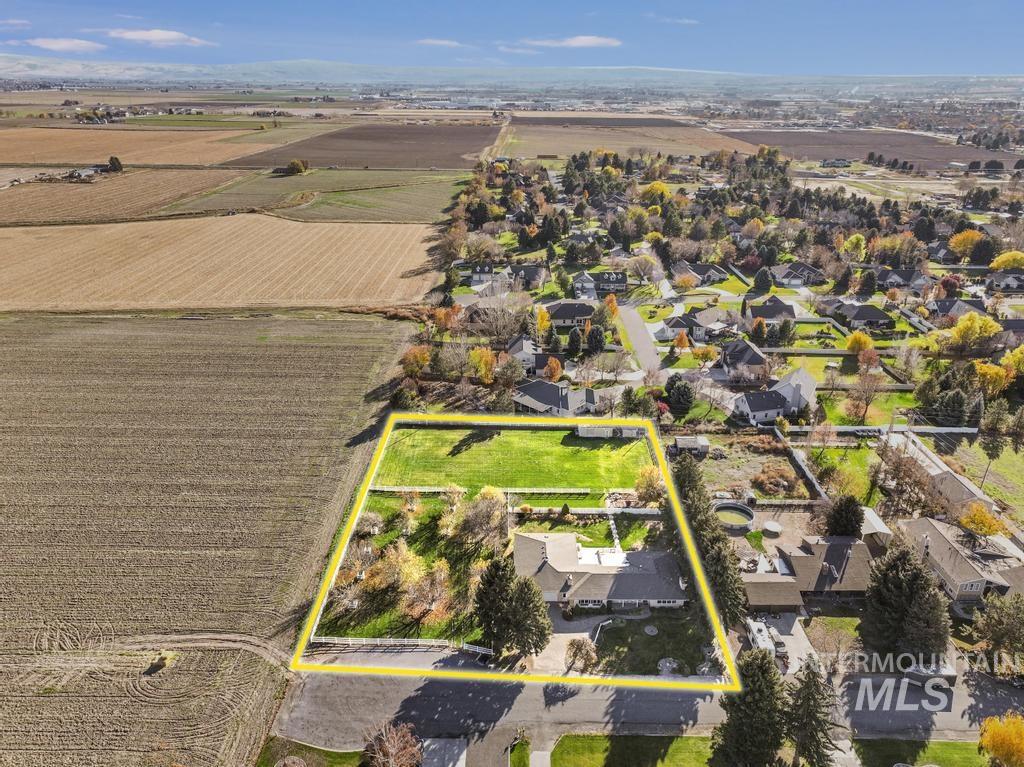 Overview of rural landscape with property parcel outlined and nearby suburban area
