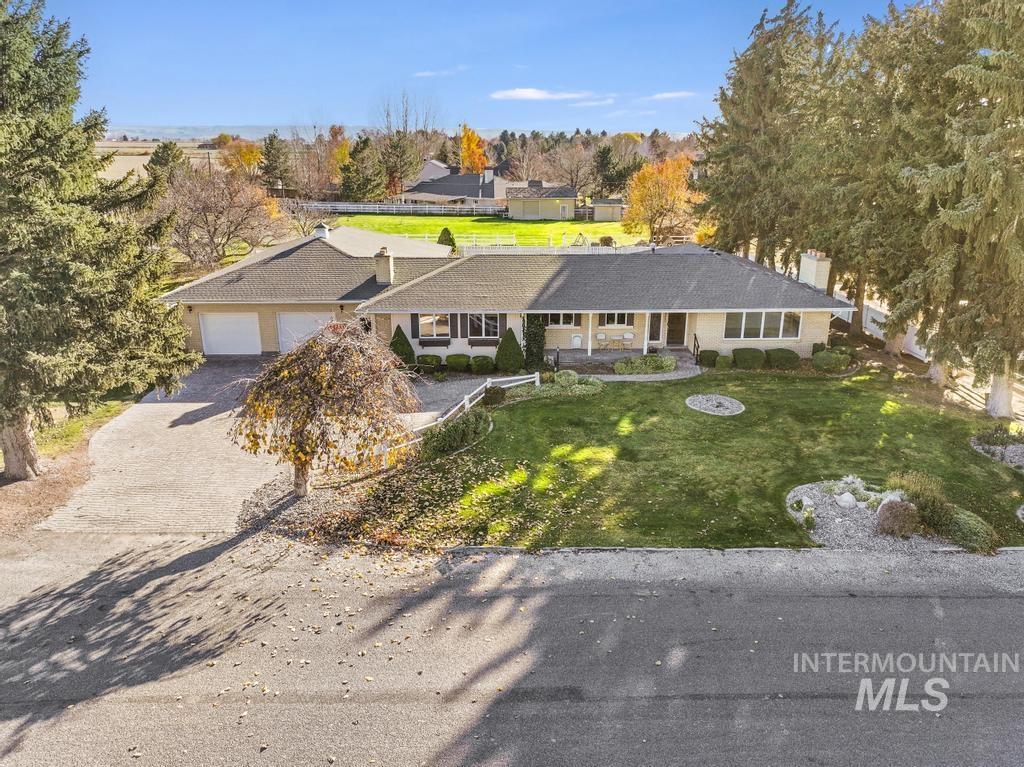 View of front of home featuring a front lawn, driveway, an attached garage, and a chimney