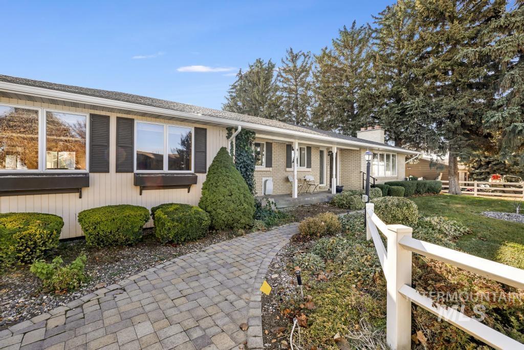 Ranch-style home with a chimney and brick siding