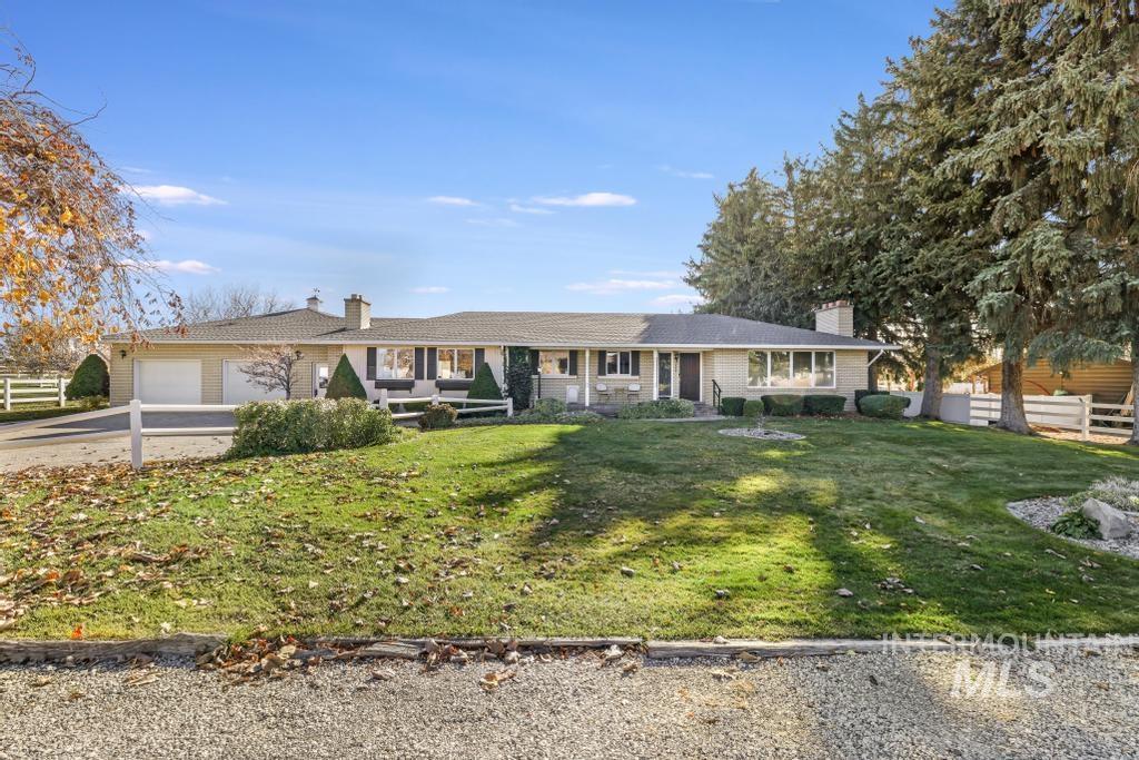 Ranch-style house with a chimney, driveway, and a garage