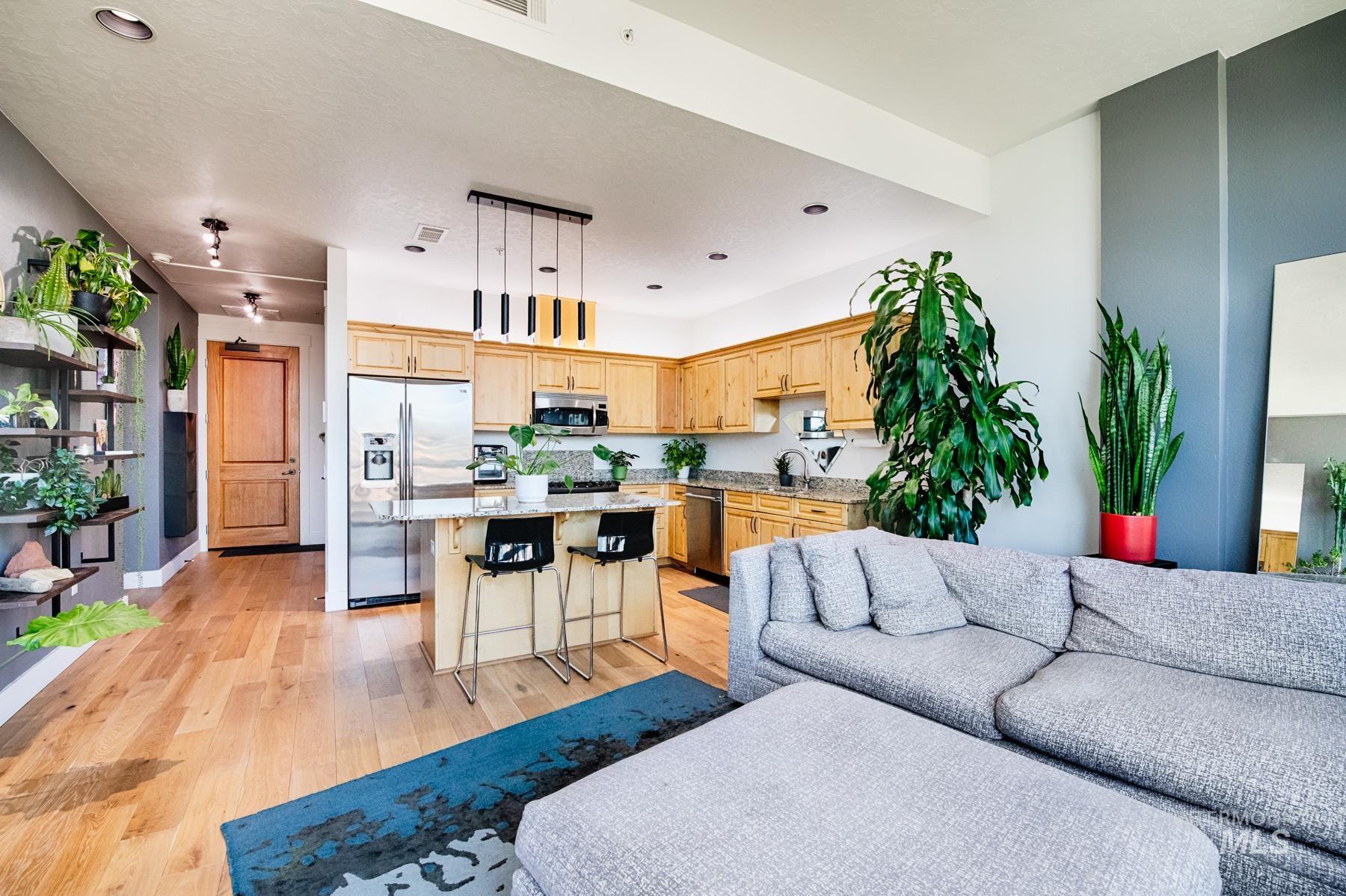 Living area with light wood finished floors and recessed lighting