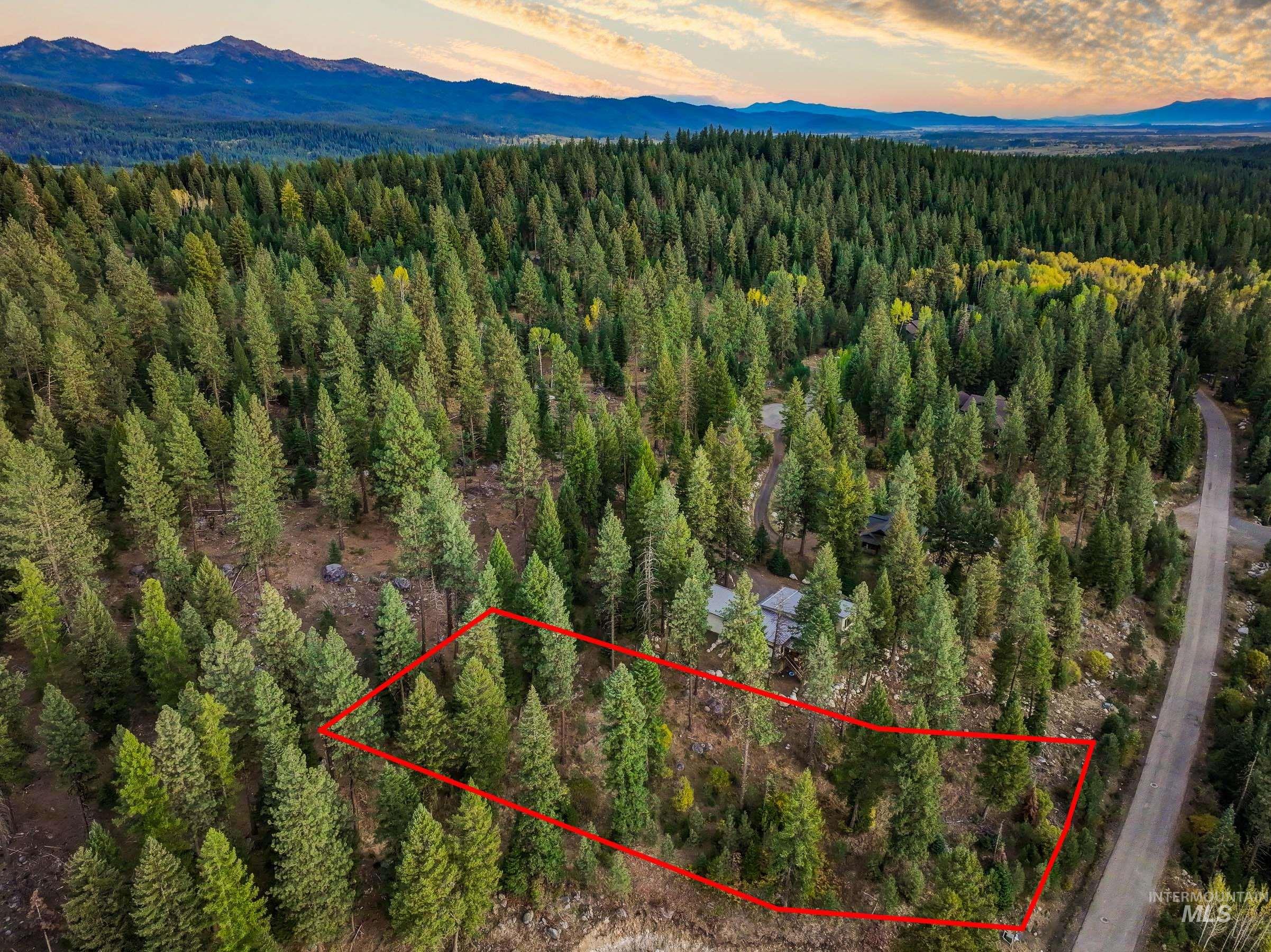 Aerial view at dusk of property parcel outlined and a mountain view