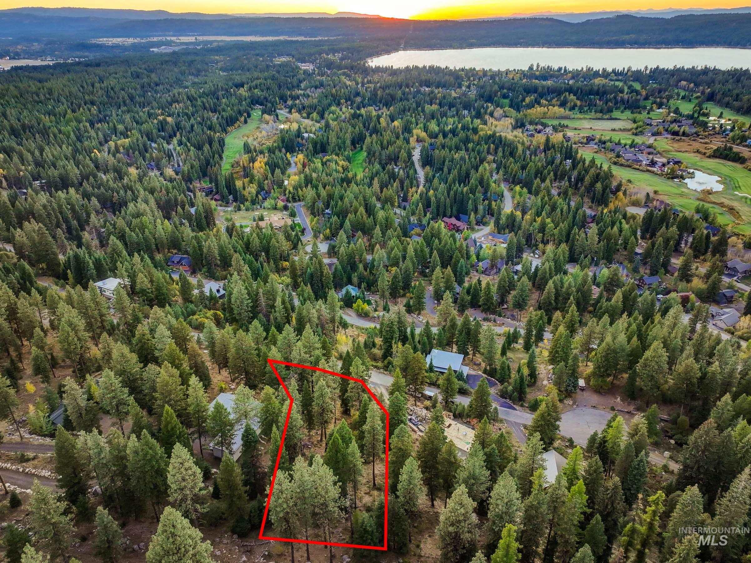 Aerial view at dusk of property boundaries highlighted, a forest view, and a water view