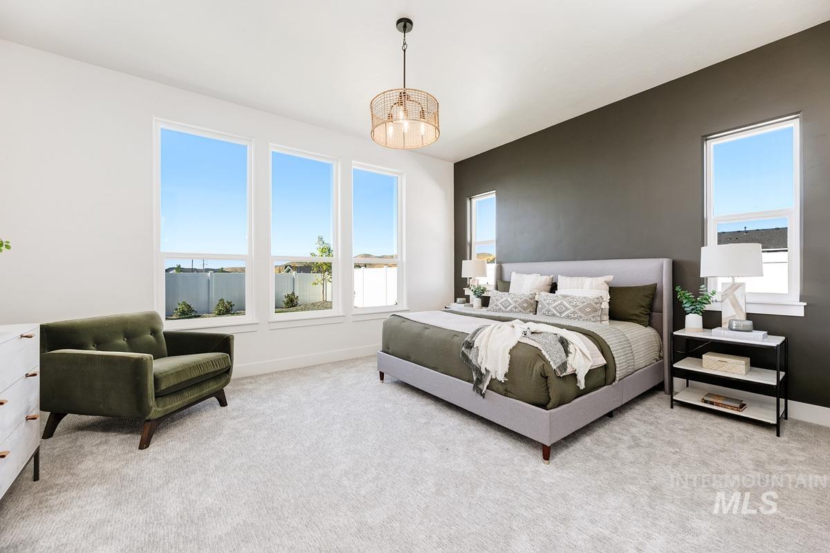 Carpeted bedroom featuring suspended lighting and baseboards