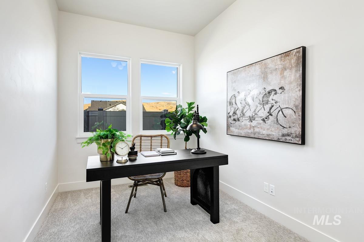 Home office featuring light carpet and baseboards