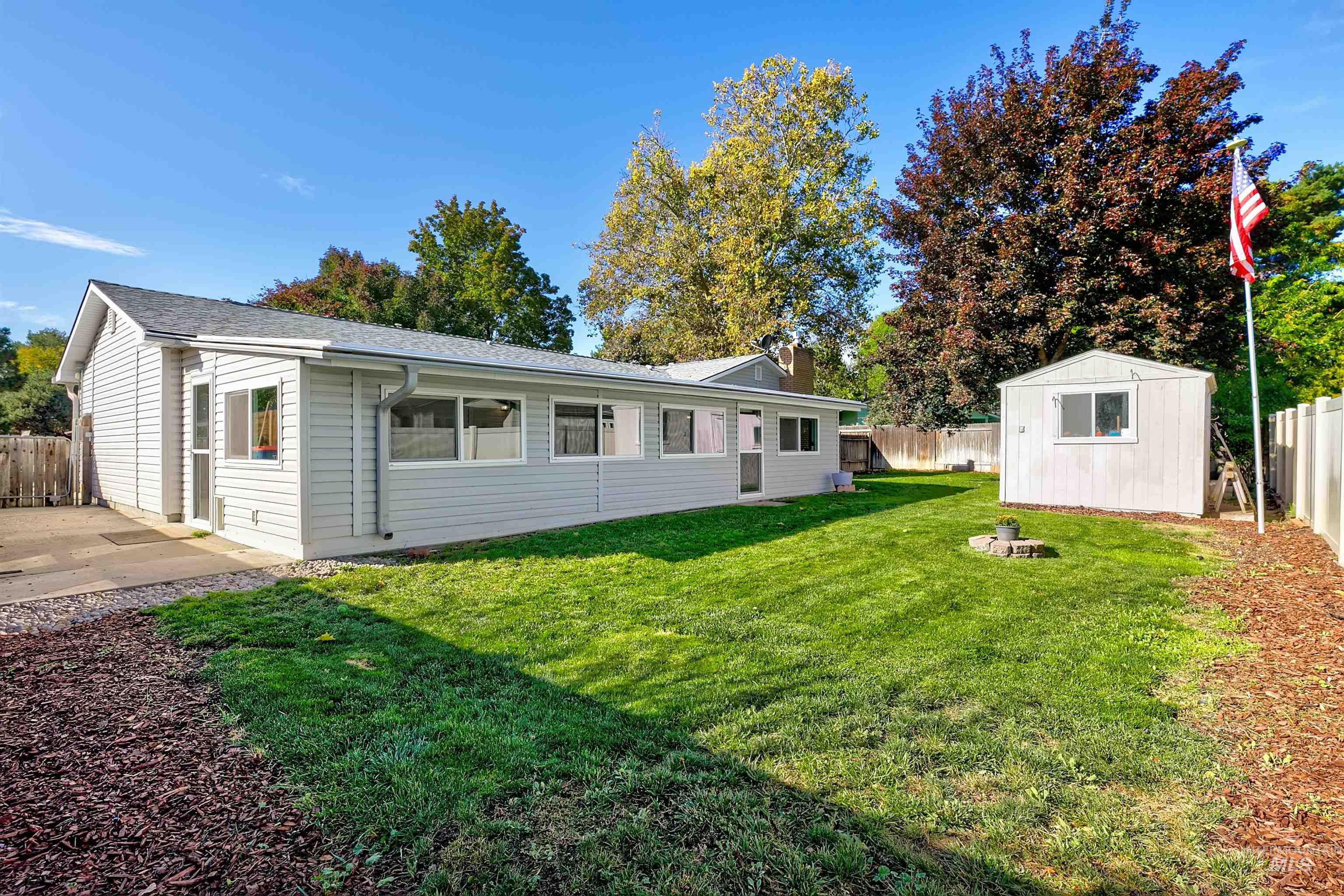Back of property featuring a fenced backyard, a storage shed, and a chimney