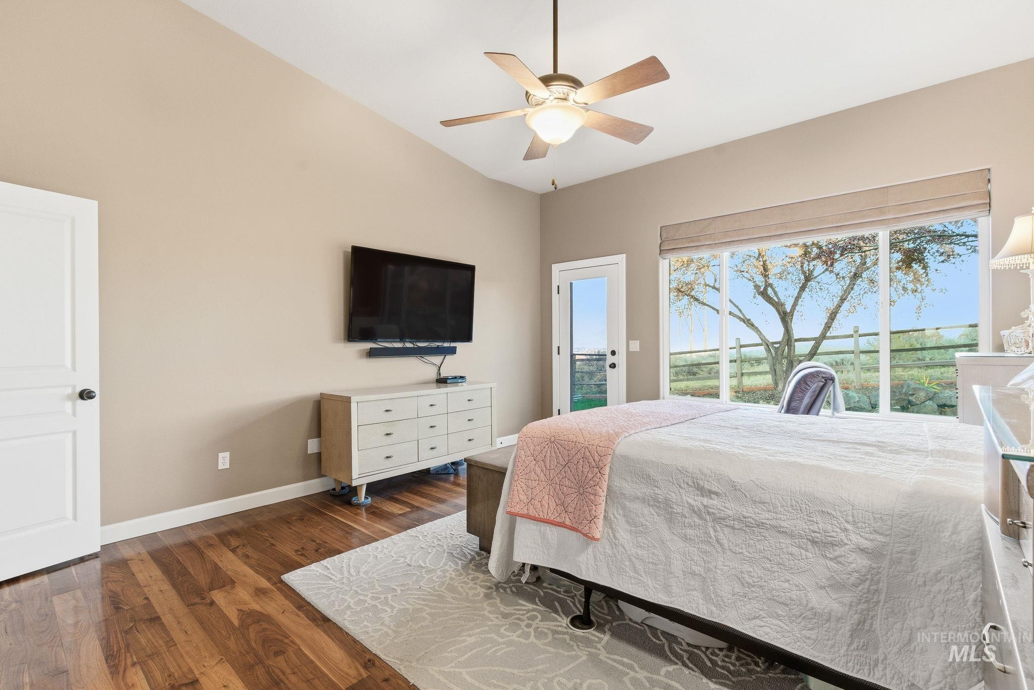 Bedroom with access to exterior, dark wood finished floors, and a ceiling fan