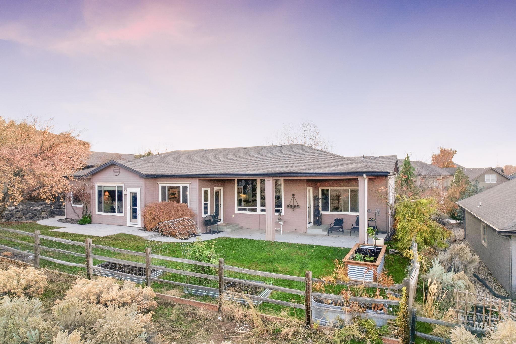 Back of property with a patio area, a fenced backyard, a garden, and a shingled roof