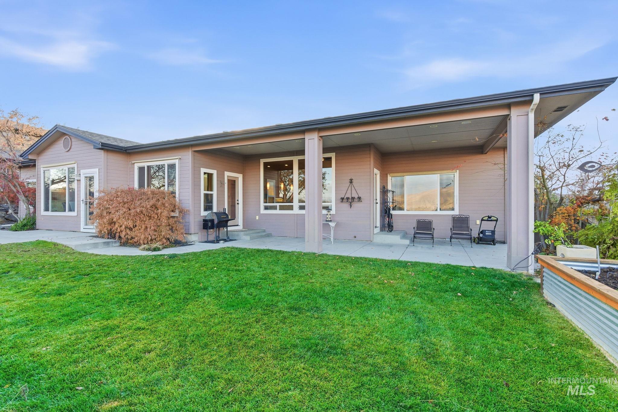 Back of property featuring a covered patio and a yard