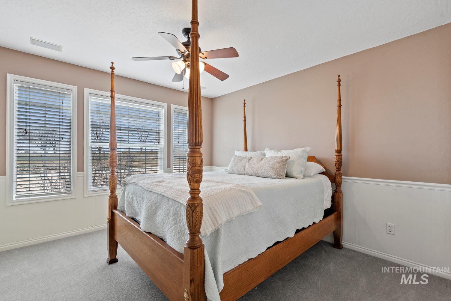 Carpeted bedroom featuring a ceiling fan and baseboards