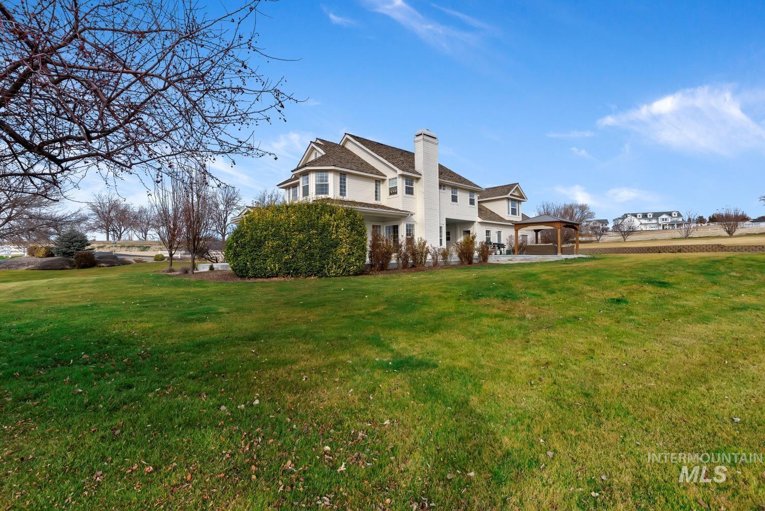 Back of property with a lawn, a patio area, and a chimney