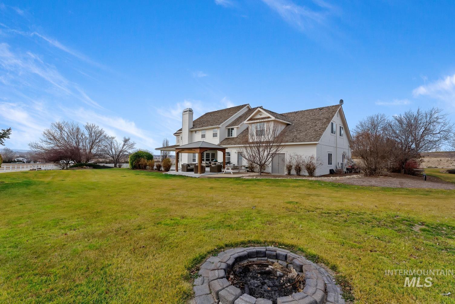 Rear view of house with an outdoor fire pit, a patio area, a yard, and a chimney