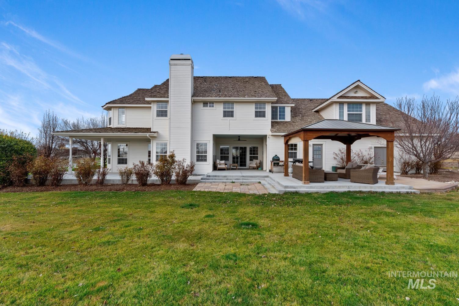 Rear view of house with outdoor furniture, a patio, a chimney, a yard, and a ceiling fan