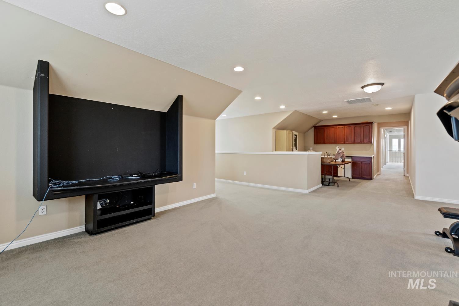 Unfurnished living room with light carpet and recessed lighting