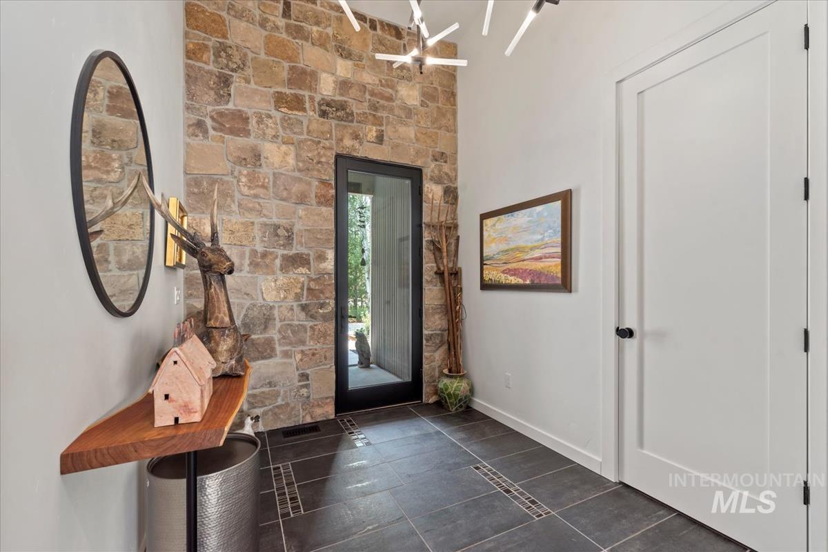 Entrance foyer featuring baseboards and dark tile patterned flooring