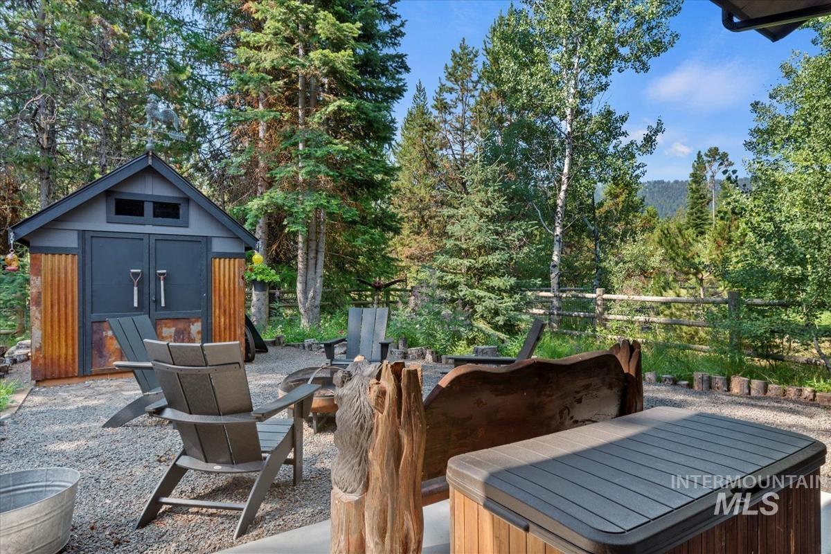 View of patio featuring a storage unit and an outdoor fire pit