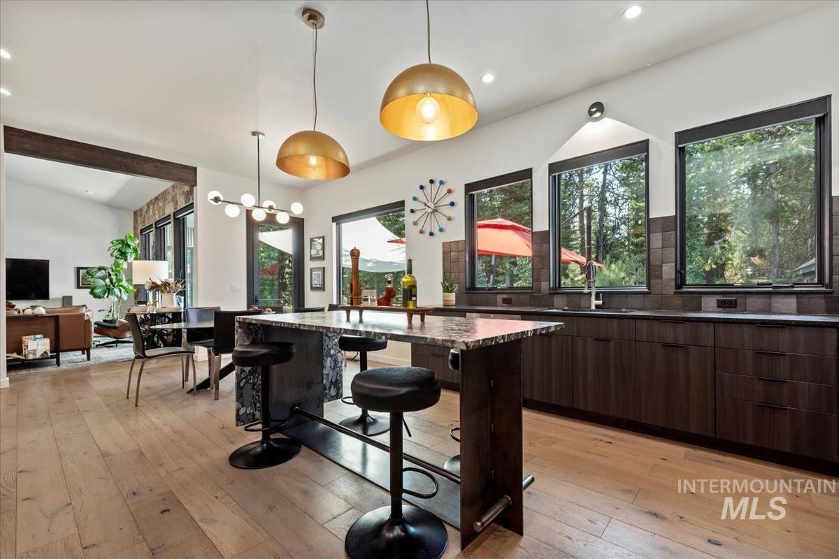 Kitchen with modern cabinets, plenty of natural light, light wood-style flooring, recessed lighting, and vaulted ceiling